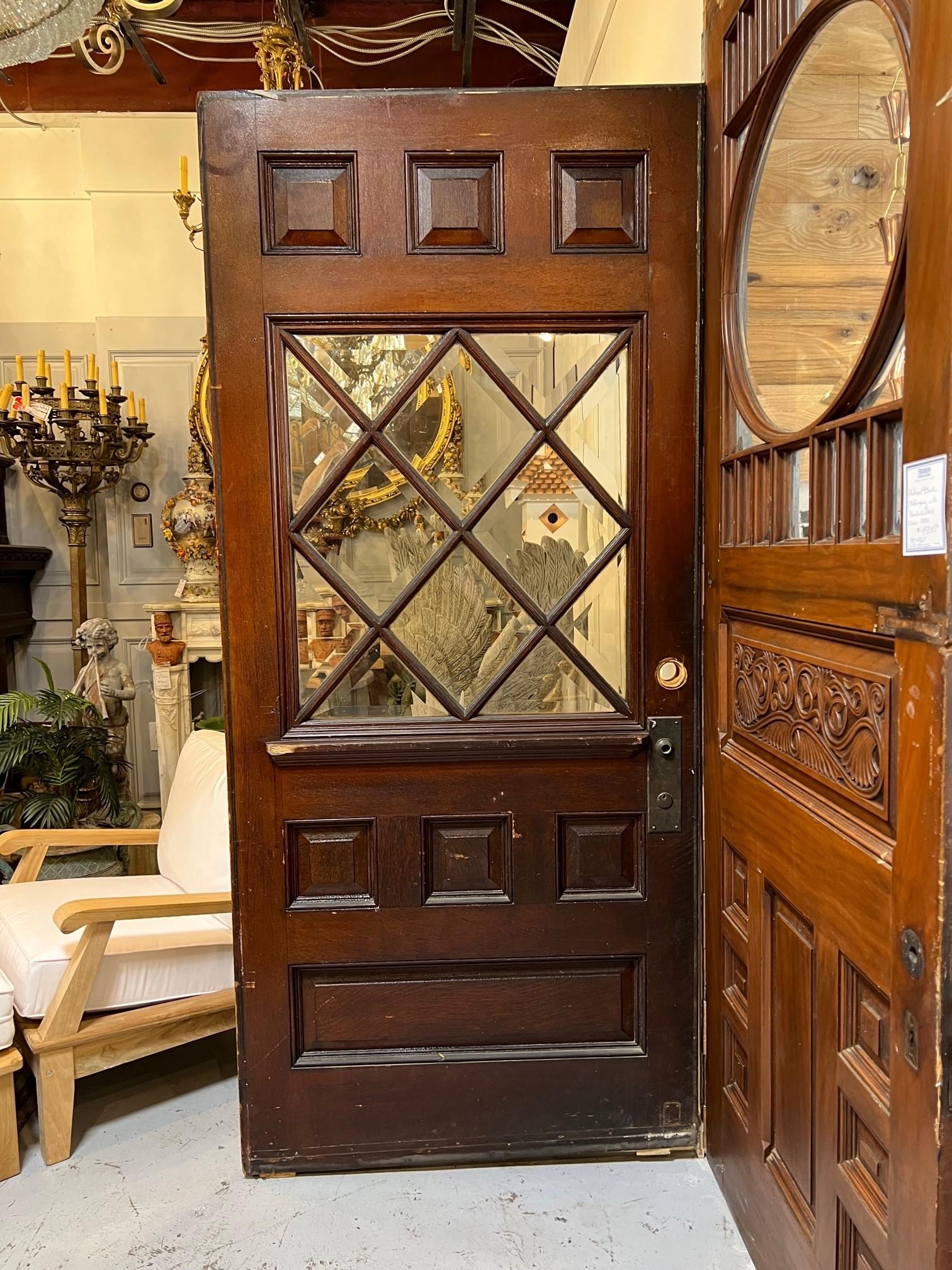 Schöne antike übergroße Eingangstür mit rautenförmigen abgeschrägten Glasscheiben und erhabenen Holzpaneelen. Diese Tür eignet sich hervorragend als Eingangstür oder als Innentür, die auf einer Schiene zwischen zwei ROOMS gleitet. Das Besondere an
