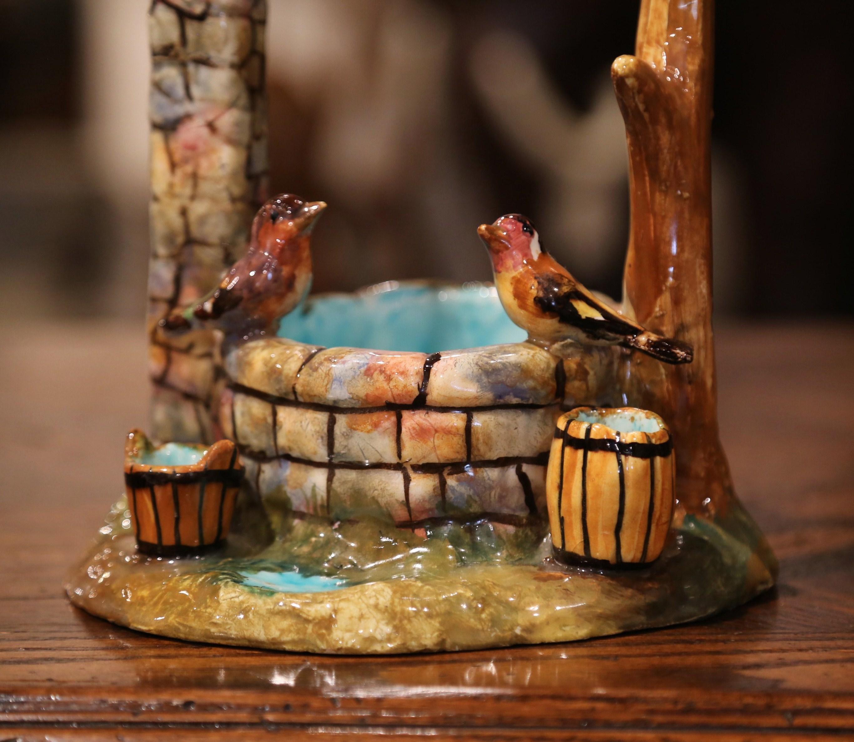 Add color to a tabletop, mantel or shelf with this colorful, antique Majolica well sculpture. The intricate barbotine piece was sculpted in France, circa 1930, and features a well with a bucket and a barrel surrounded by four birds. The hand