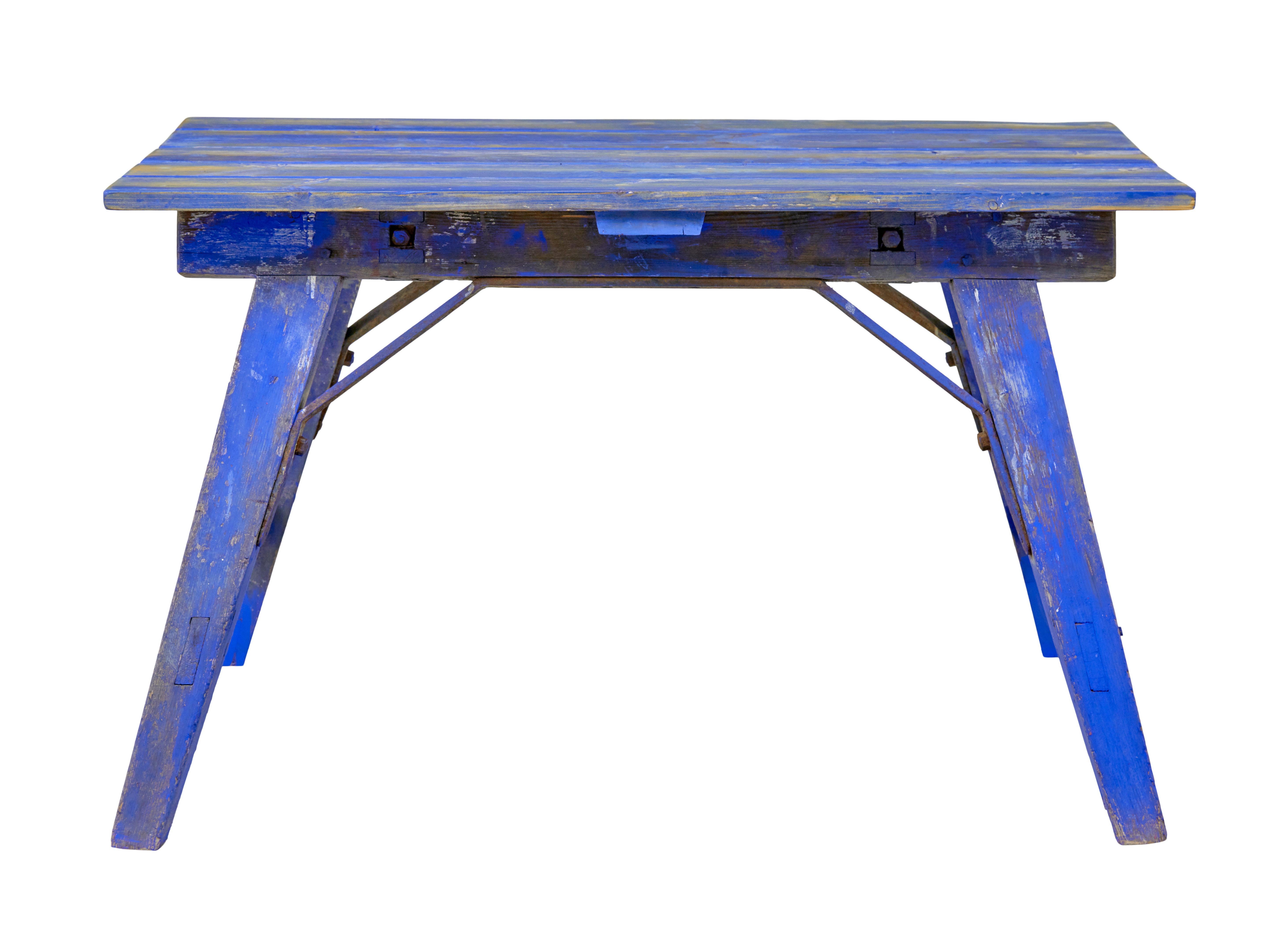Tavolo da lavoro in pino dipinto dei primi del Novecento, circa 1900.

Base di tavolo industriale dipinta con vernice blu originale di grande effetto, presentata con un piano in pino associato, che sarebbe stato realizzato a metà del XX secolo.

Il