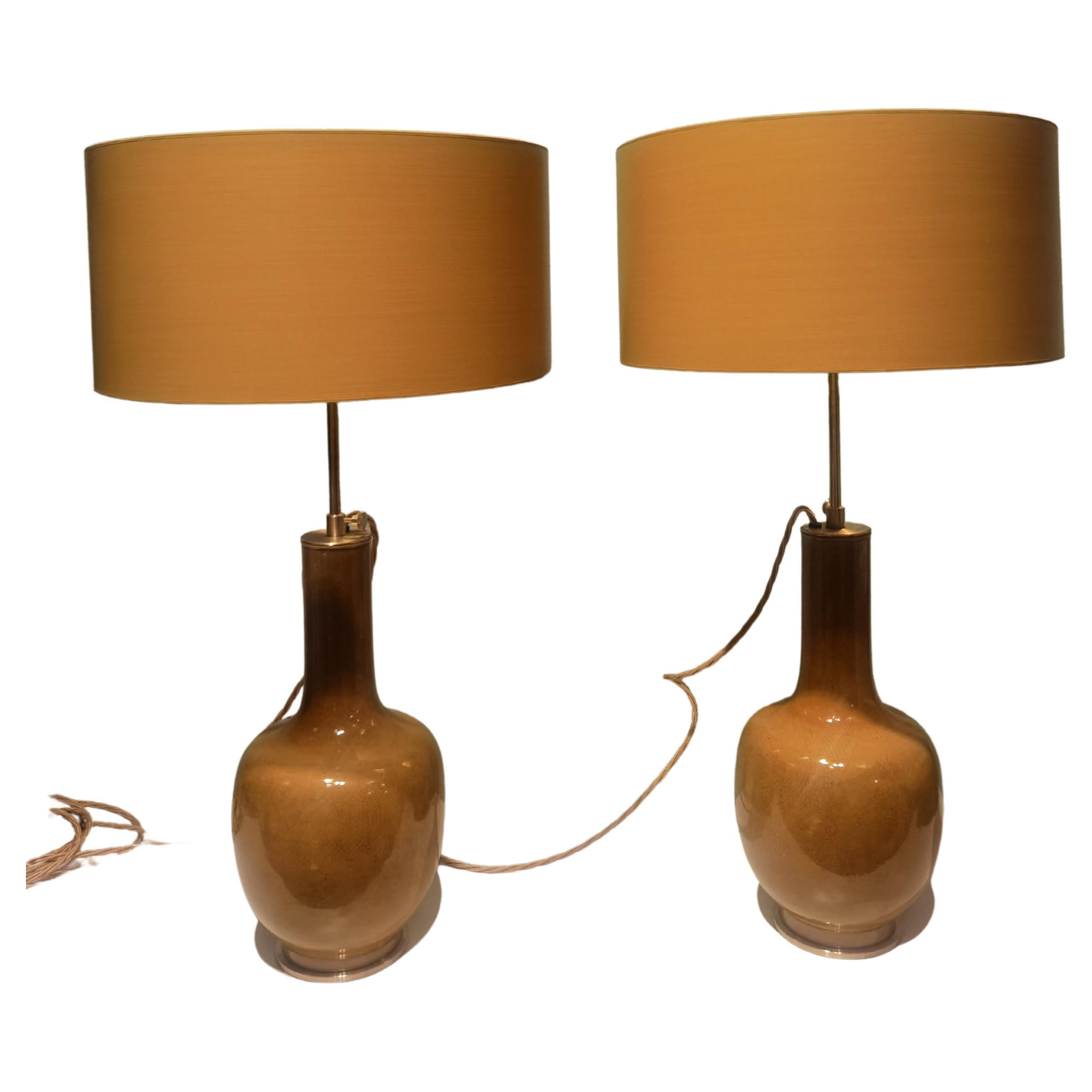 Pair of chinoiserie table lamps made from a pair of ochre glazed porcelain bottle vases from the early 20th century. Transformed to table lamps with solid brass ends by Sofina Boutique Kitzbühel with a handmade and handpainted lampshade in ochre.