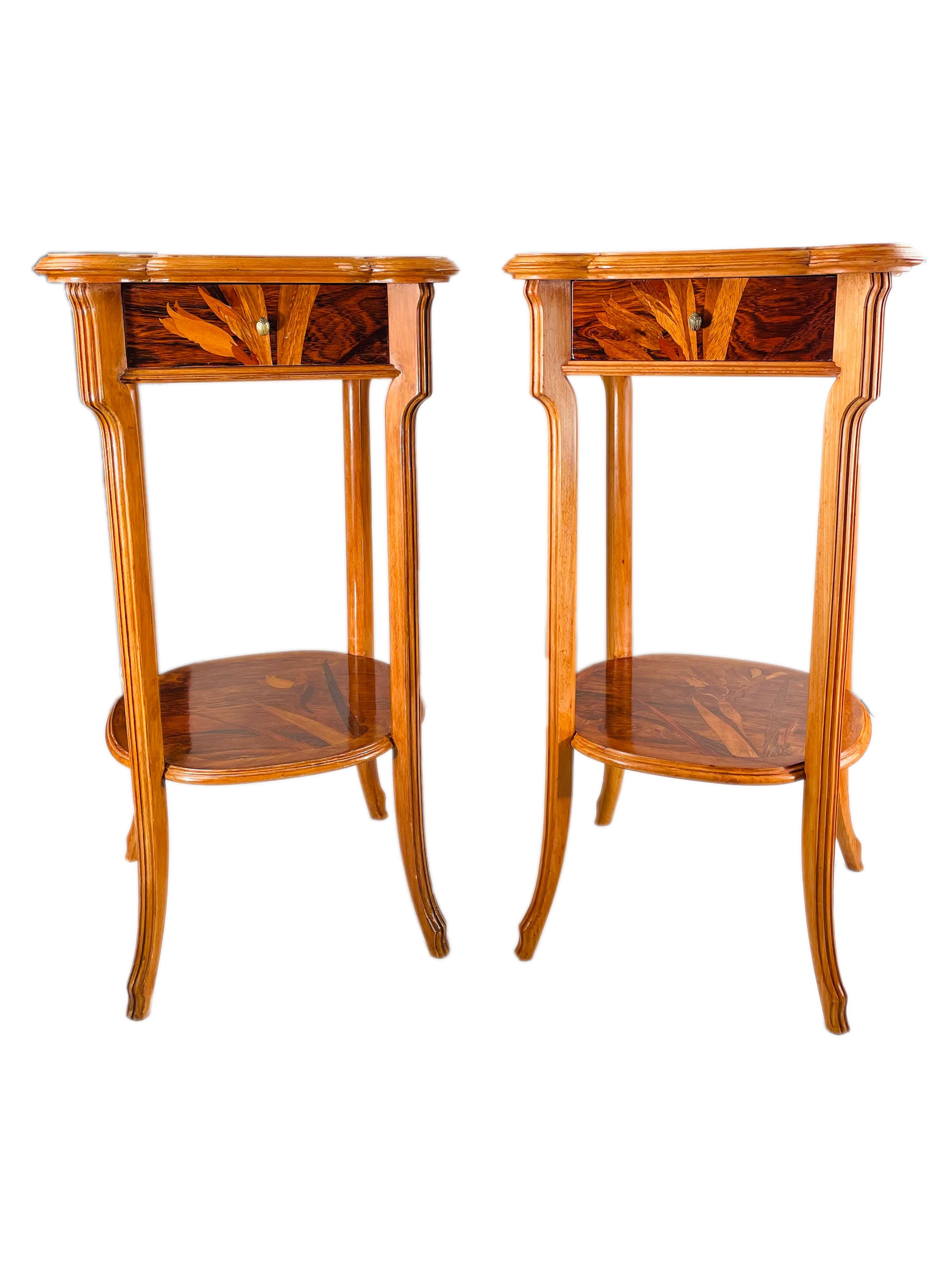 An early 20th century pair of French Art Nouveau occasional tables by, Emile Gallé carved legs further decorated with exotic wood marquetry inlay of flora on the top, drawers, sides, and lower shelf . The tables both have a single drawers each