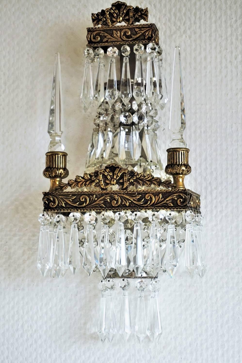 A lovely pair of French Empire style cut crystal and bronze wall sconces with cut shaped drops and cut crystal spires, 1900s.
Measures:
Height 17 in (43 cm)
Width 7.25 in (18.5 cm)
Depth 4 in (10 cm)
One light socket.

We have a fitting mirror at