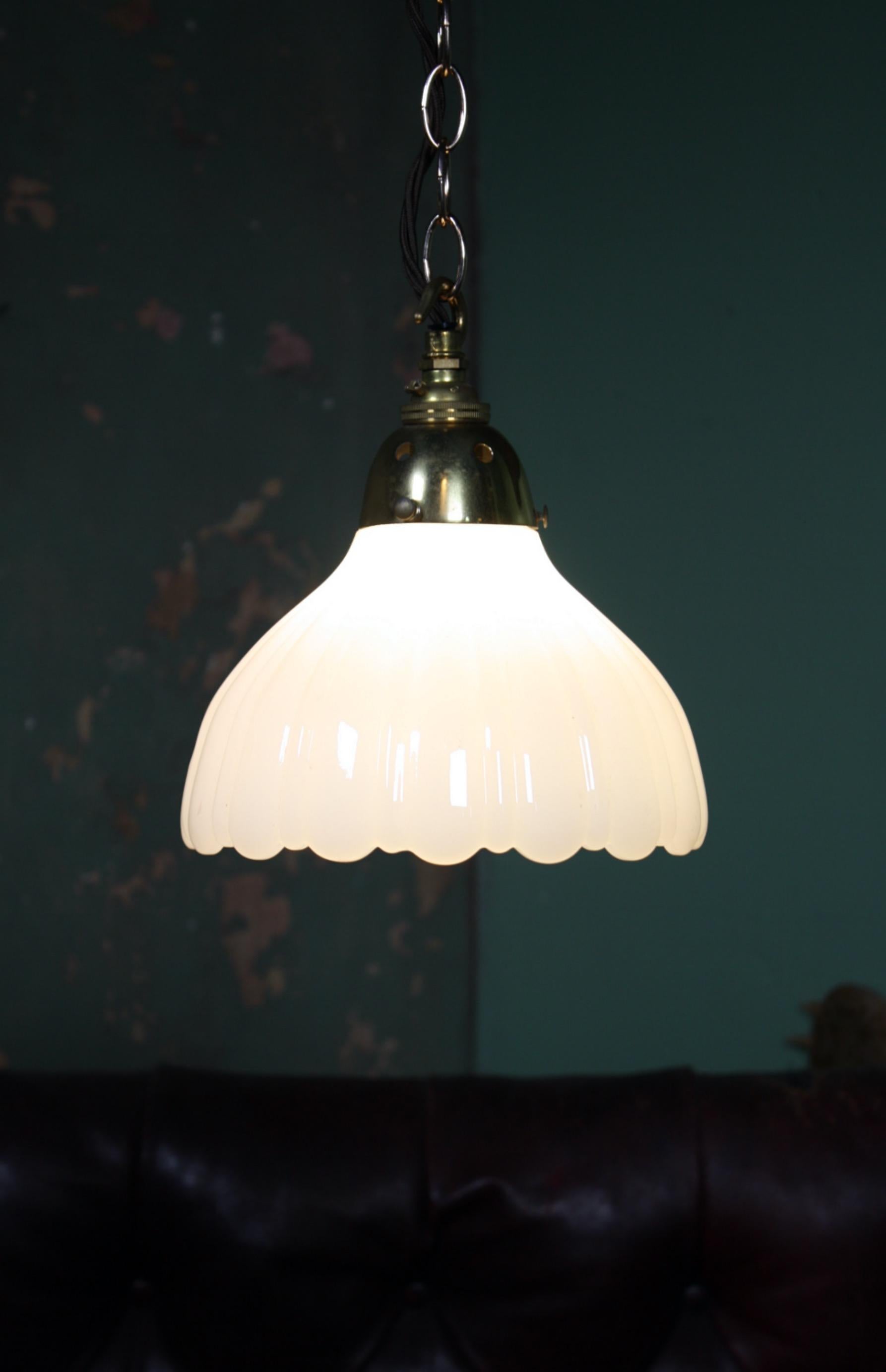 A good clean pair of early 20th century Jefferson milk glass pendant. 

Thick pressed glass with original decorative brass galleries, a new antique style brass hooked bayonet bulb holder has been installed, the lights also comes with a length of