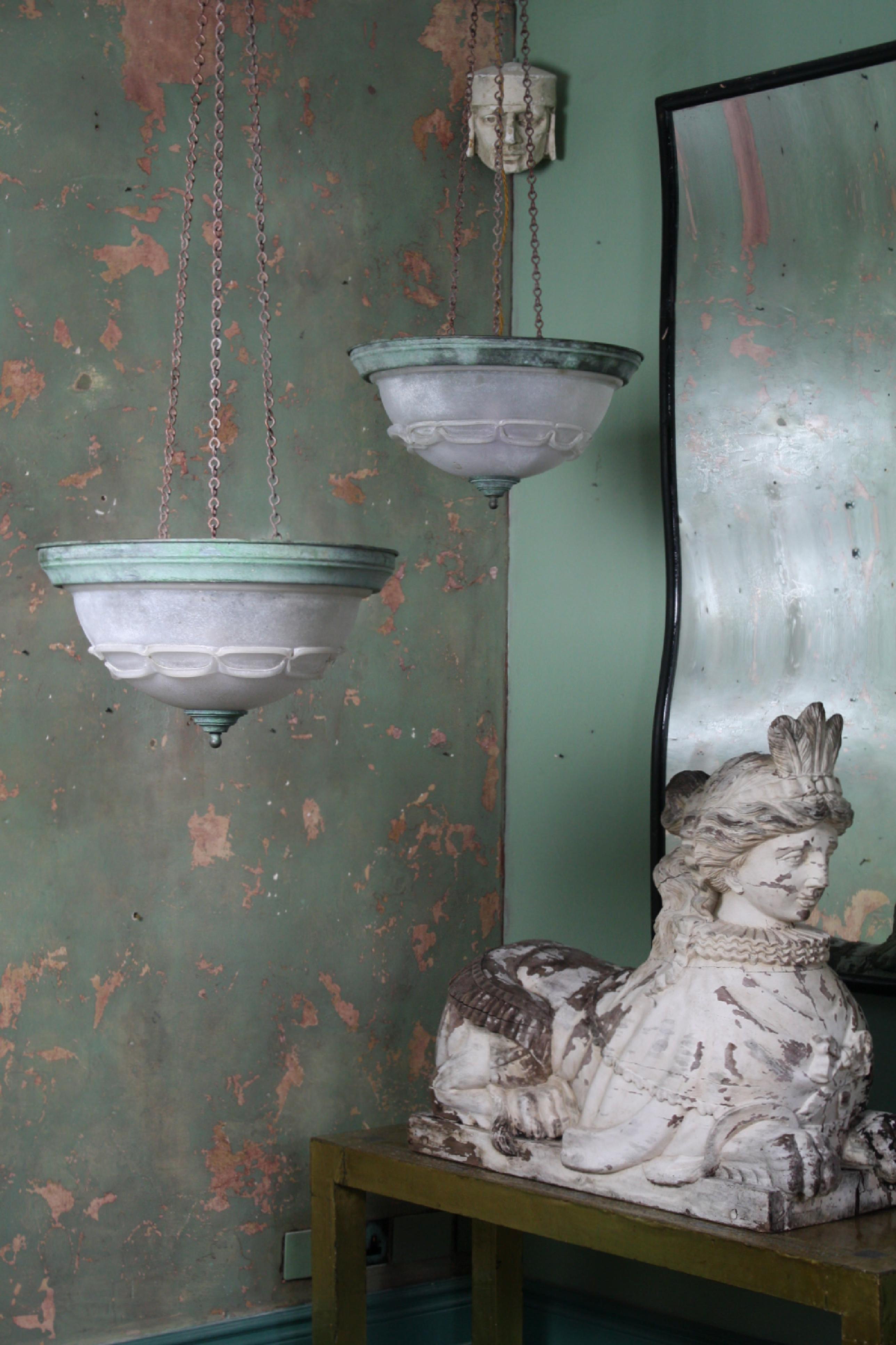 A very unusual pair of 20th century (second quarter) plafonnier pendants in the neoclassical style, with depth glass bowls and applied decoration. These would of originally been flush mounted to a outdoor ceiling or wall and have at some point in