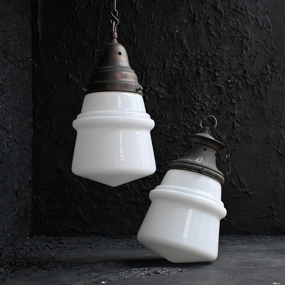 Early 20th Century pair of opaline glass pendants  

With brass and copper different shaped light galleries this pair of light pendants have identical glass opaline shades. Giving of a soft glow these lights would look highly decorative situated in