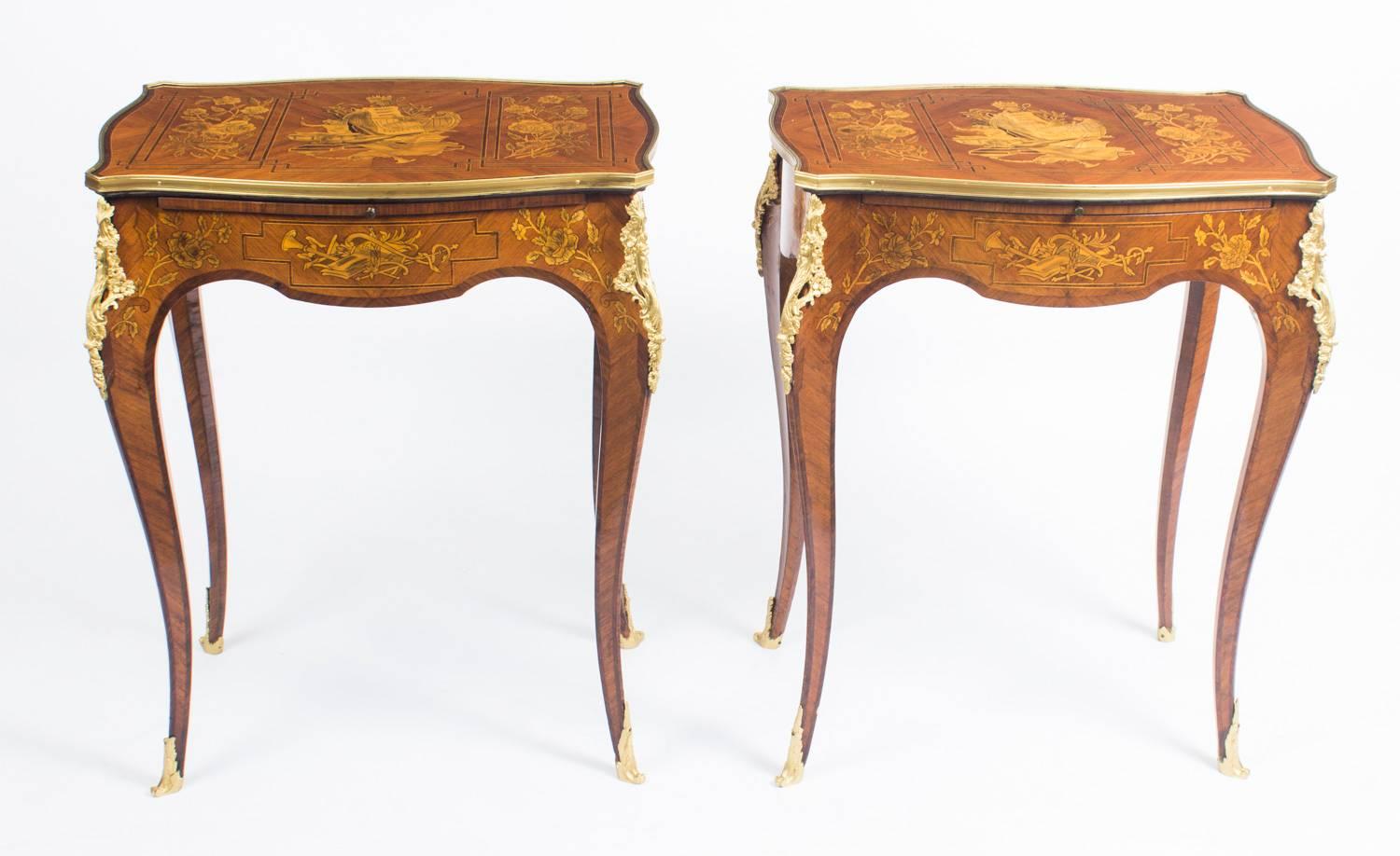 This is a stunning pair of antique French oval marquetry and ormolu mounted occasional tables, circa 1900 in date.

The elegant tables feature shaped rectangular tops inlaid with rectangular panels of putti and musical instruments flanked by panels