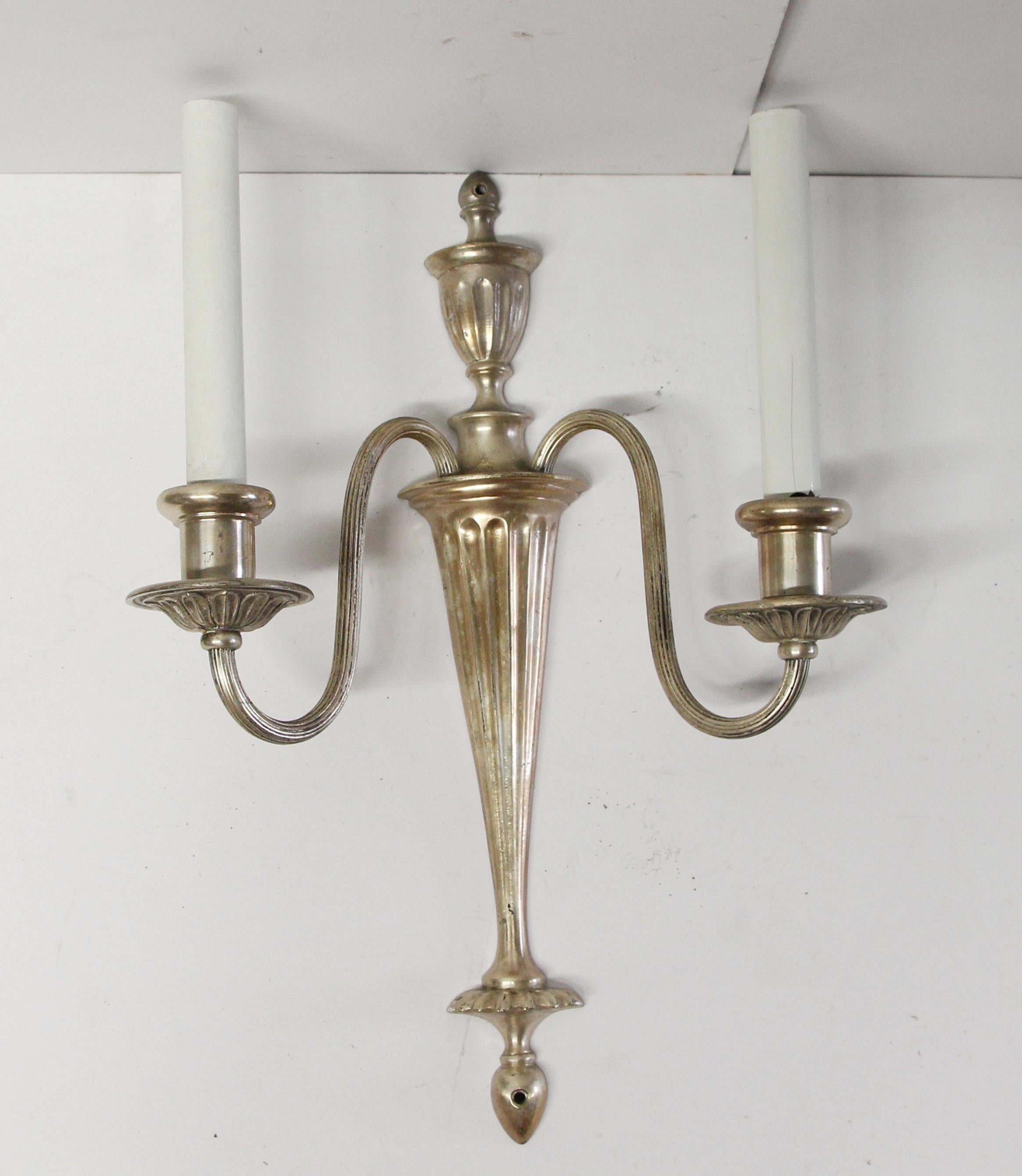 Classic Federal style two arm sconces made of silvered brass. Fluted urn style center with narrow arms and pineapple finials, circa 1920. Priced as a pair. This can be viewed at our Scranton, Pennsylvania location. Please inquire for the exact