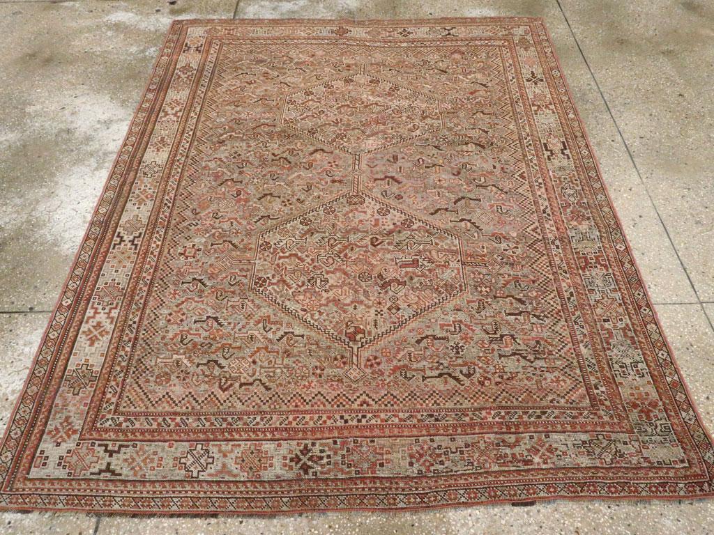 Una antigua alfombra persa Khamseh de acento. Gallinas y botehs (paisleys) llenan el medallón de asta de rombo doble escalonado y se derraman sobre el campo de grafito y caqui en un característico diseño tribal Khamseh del sur de Persia. El borde