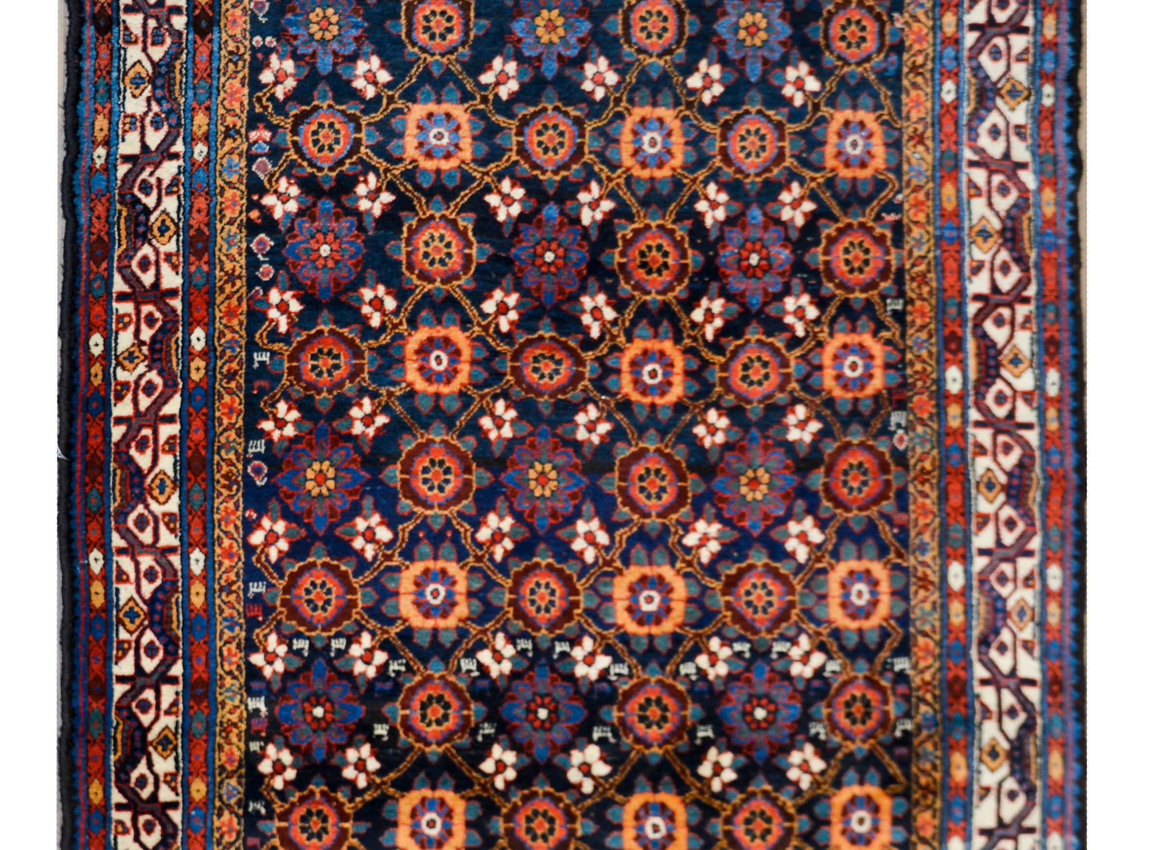 Maravillosa alfombra persa Afshar de principios del siglo XX, con un maravilloso motivo floral enrejado por toda la superficie, tejido en atrevidos tonos carmesí, índigos, blancos y dorados, sobre un fondo índigo oscuro y rodeado de un borde con un