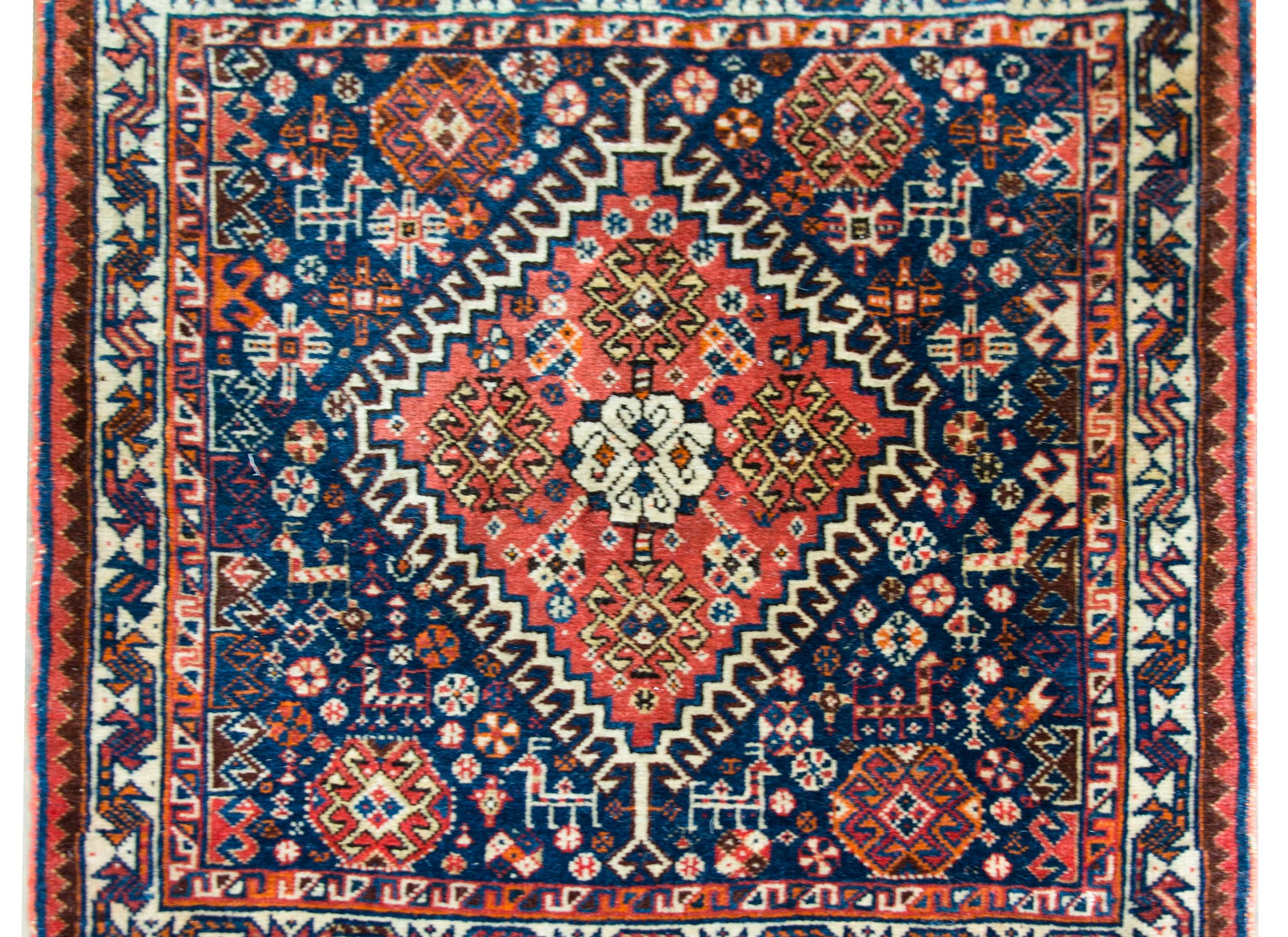 Bellissimo tappeto persiano Afshar dell'inizio del XX secolo con un fantastico motivo che contiene un grande medaglione centrale a diamante con fiori stilizzati e che vive in mezzo a un campo di piccoli fiori stilizzati e capre, tutti tessuti in