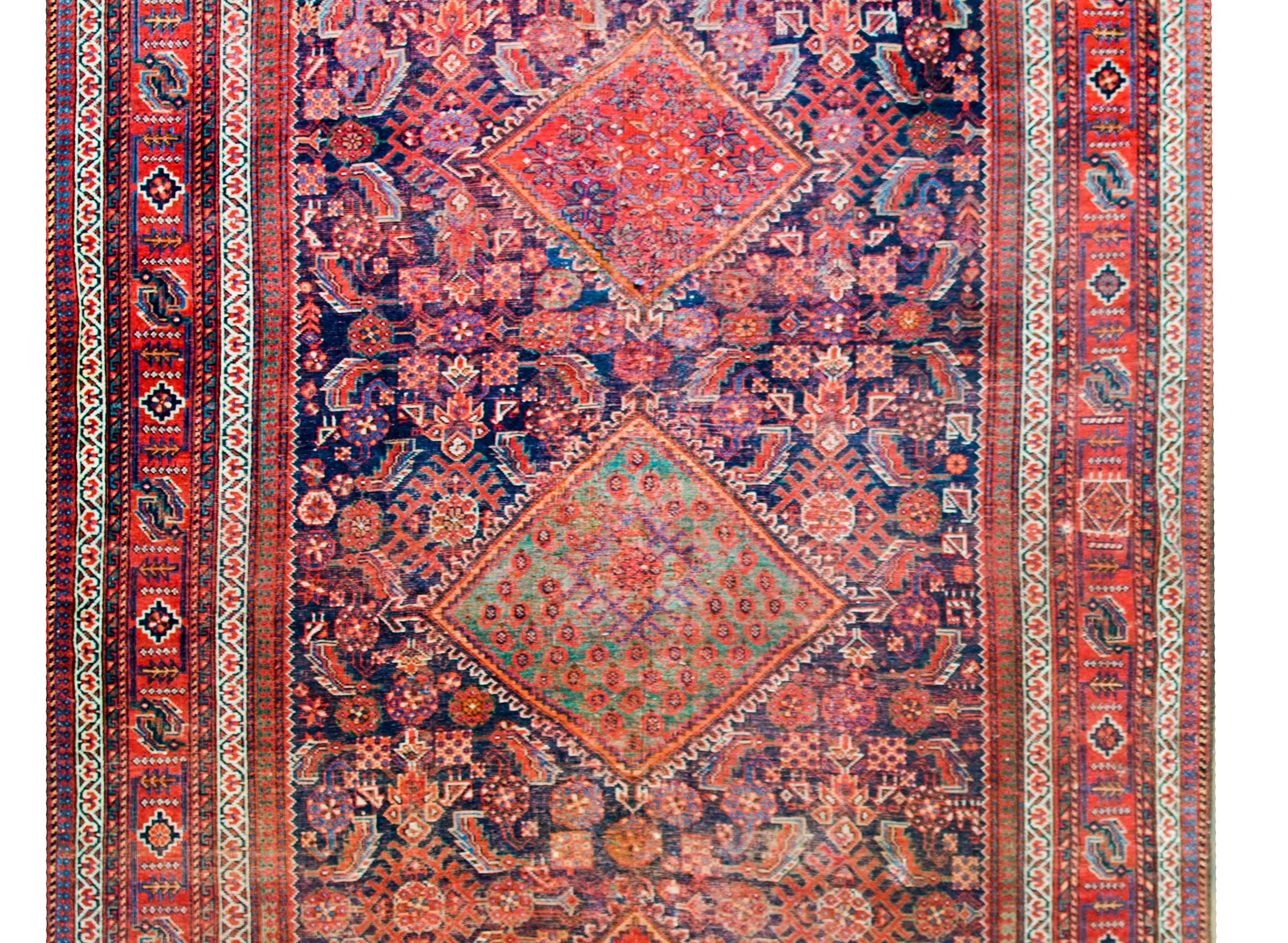 Ein atemberaubender persischer Afschar-Teppich aus dem frühen 20. Jahrhundert mit drei großen Rautenmedaillons, die inmitten eines Spalierfeldes mit stilisierten Blumen und Blättern schweben, umgeben von einer komplexen Bordüre, die mehrere breite