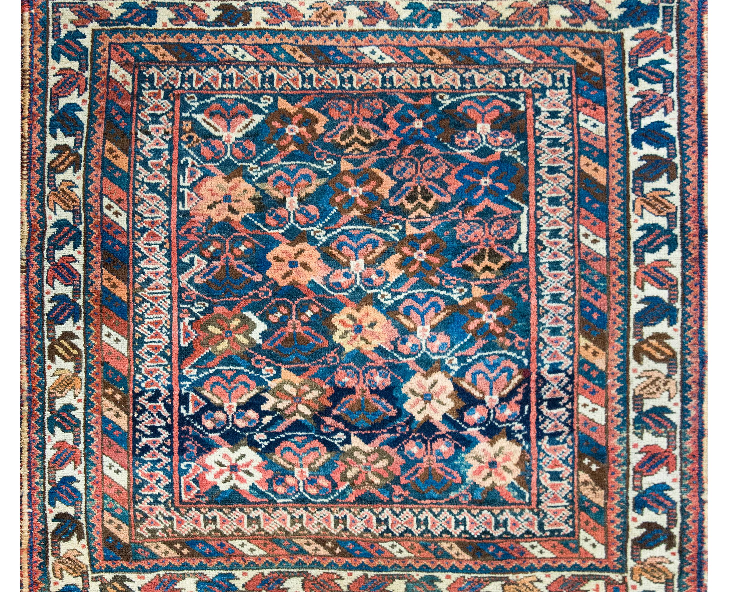 Ein bezaubernder und einzigartiger persischer Afschar-Teppich aus dem frühen 20. Jahrhundert mit einem sich wiederholenden stilisierten Blumenmuster, das fast an Schmetterlinge erinnert, quer über das Feld, umgeben von einer komplexen Bordüre mit
