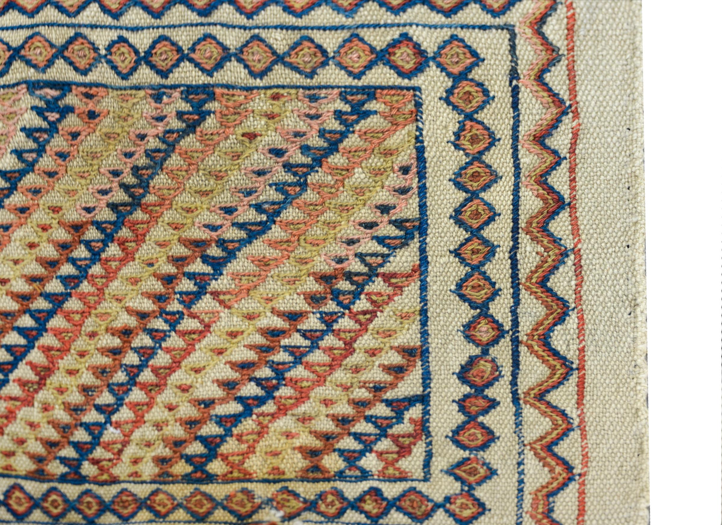 An early 20th century Persian Azari flat hand woven rug with ends embroidered with multi-colored triangle patterned stripes and surrounded by more geometric stripes.