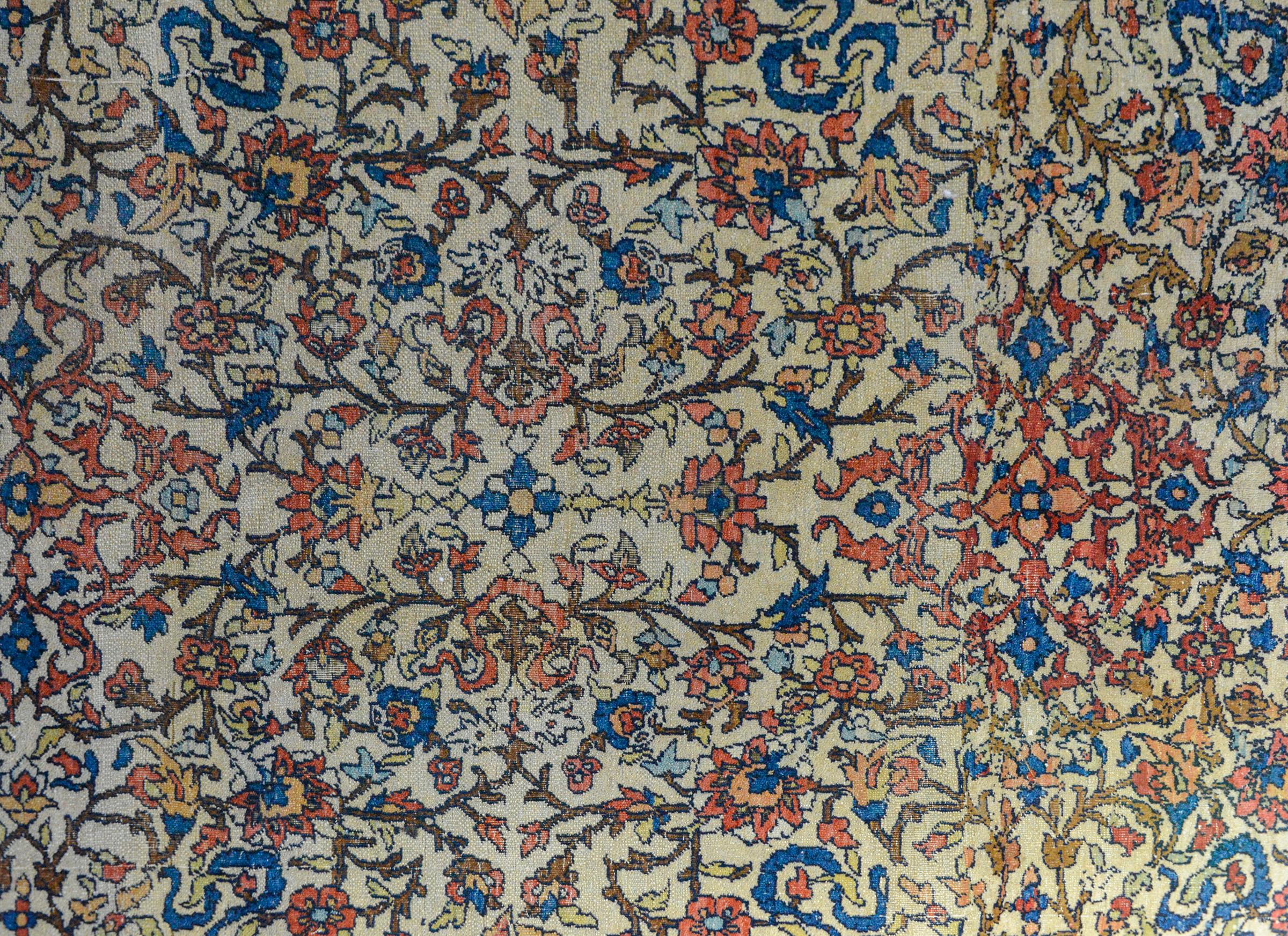 An incredible early 20th century Persian Bakhtiari rug with an all-over floral and scrolling vine pattern woven in crimson, pink, indigo, gold, and brown, all against a cream background. The border is unusual with a large-scale floral outer border