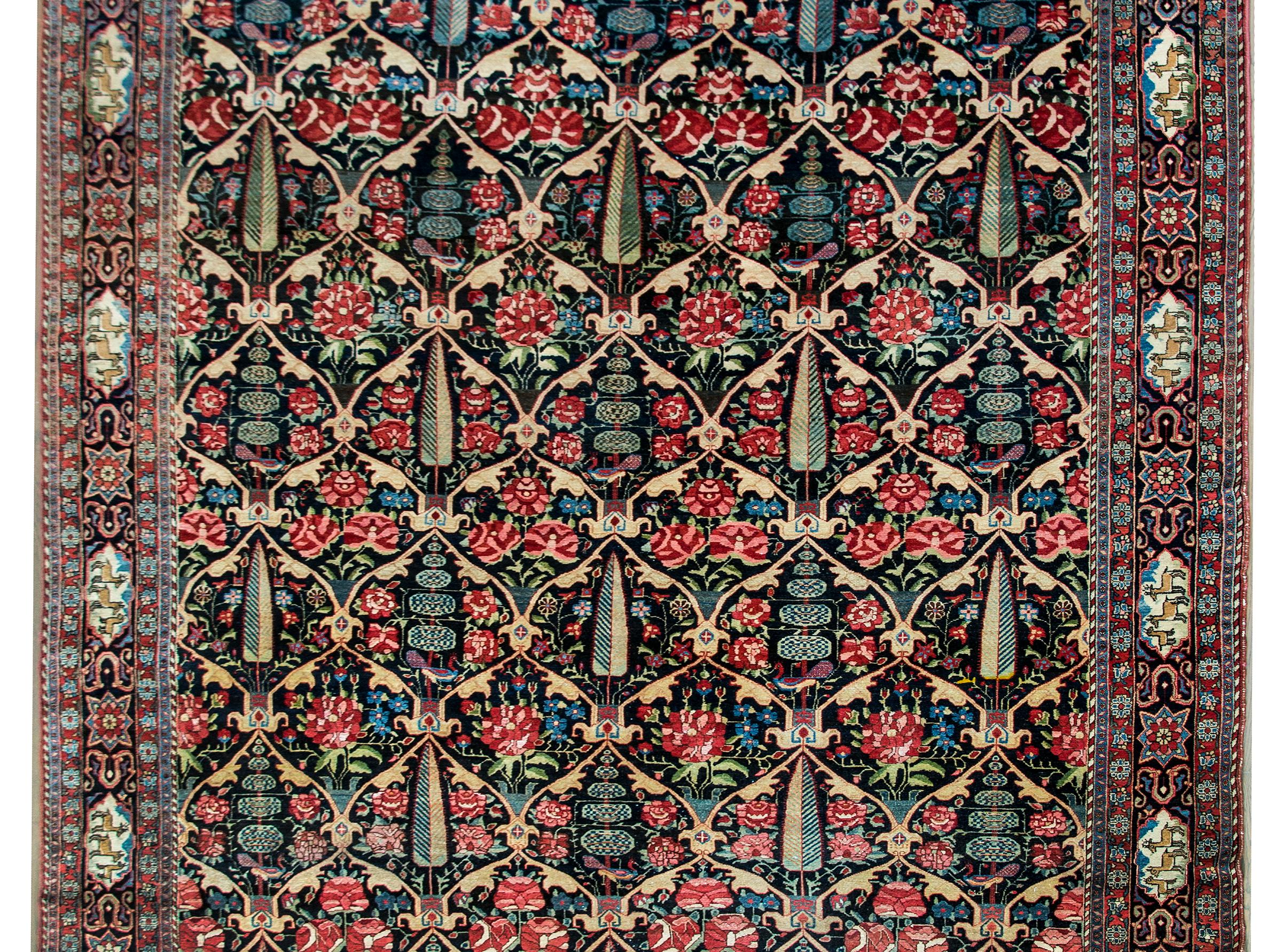 An absolutely stunning and chic early 20th century Persian Bakhtiari rug with an all-over William Morris-esque trellis pattern with cypress trees, topiaries, and large roses, and surrounded by a wide border with deer medallions living amidst more