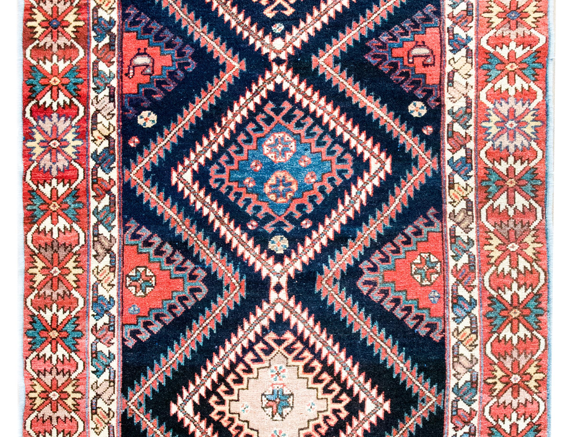 Ce tapis persan Bakhtiari du début du XXe siècle présente une géométrie audacieuse et une riche palette qui définissent les plus belles traditions de tissage tribal de l'ouest de l'Iran. Tissé à la main par le peuple Bakhtiari - des communautés