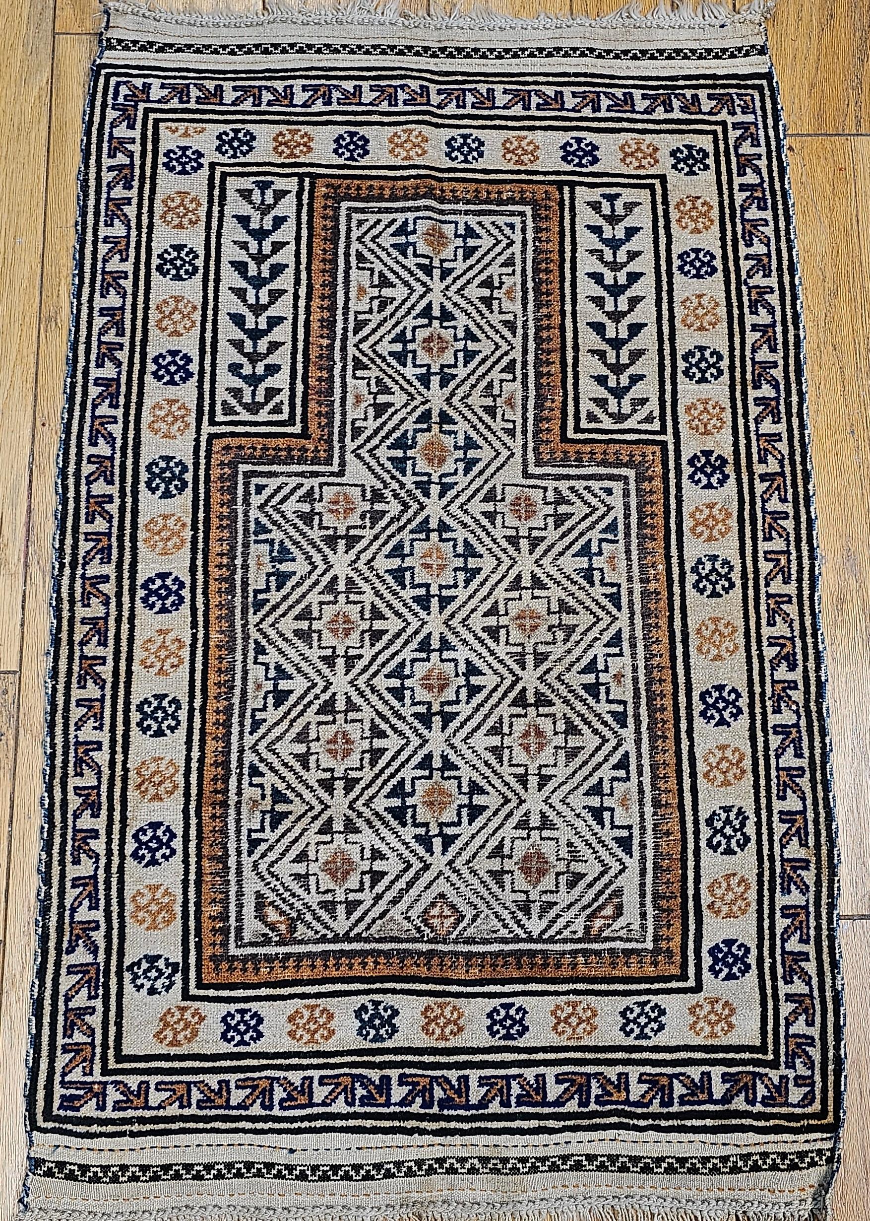 A rare and beautiful early 20th-century Baluch tribal area rug featuring a classic prayer rug design. This exceptional vintage piece is distinguished by its uncommon ivory background—a seldom-seen feature in Baluch weavings—complemented by a