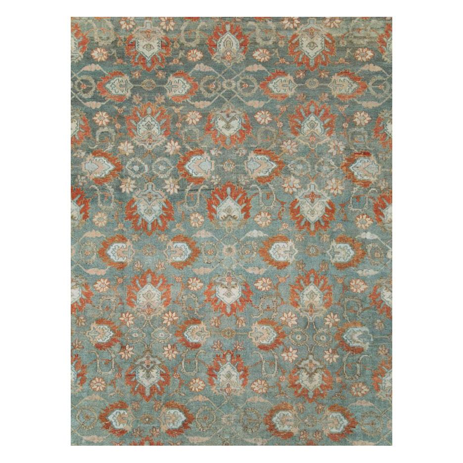 An antique Persian Bibikabad large oversized carpet handmade during the early 20th century with rust red palmettes and border, and a slate grey field.

Measures: 12' 8