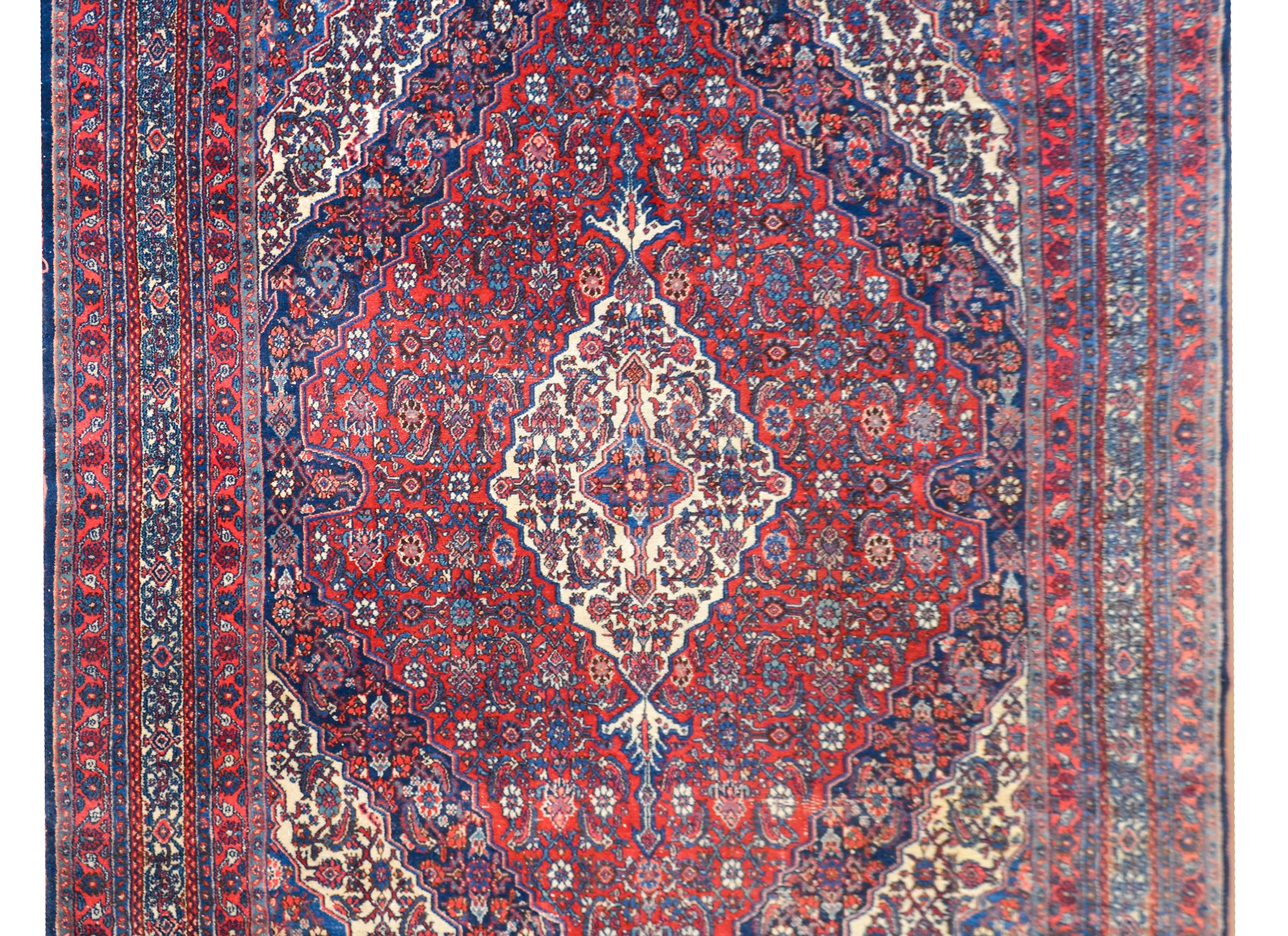 A wonderful early 20th century Persian Bibikabad rug with a diamond medallion set against a floral partnered field of flowers, and surrounded by a complex border with multiple petite floral patterned stripes.