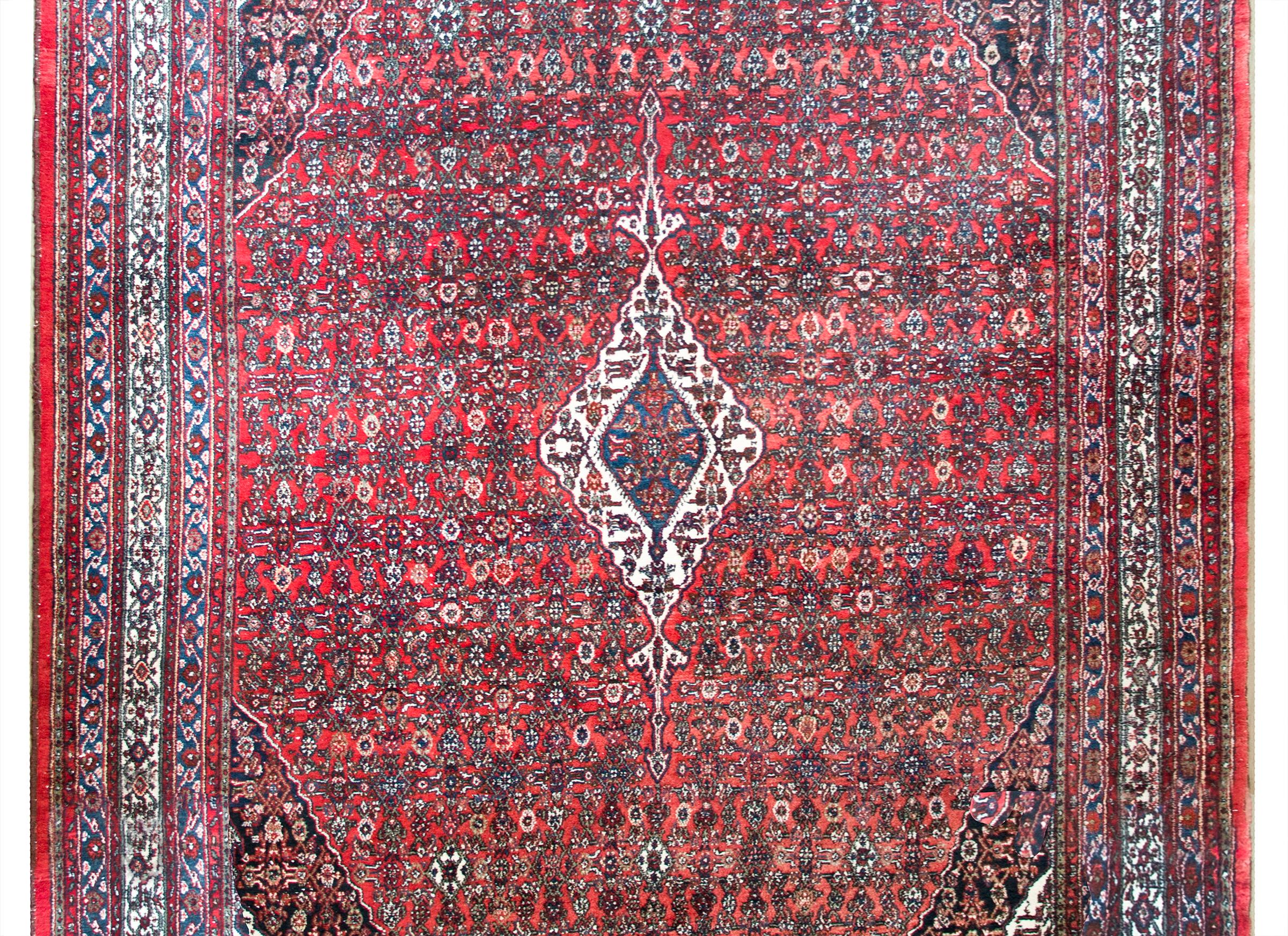 A beautiful early 20th century Persian Bibikibad rug with an all-over trellis floral pattern with a small central white diamond medallion, and a wide border composed of multiple thin petite floral patterned stripes.