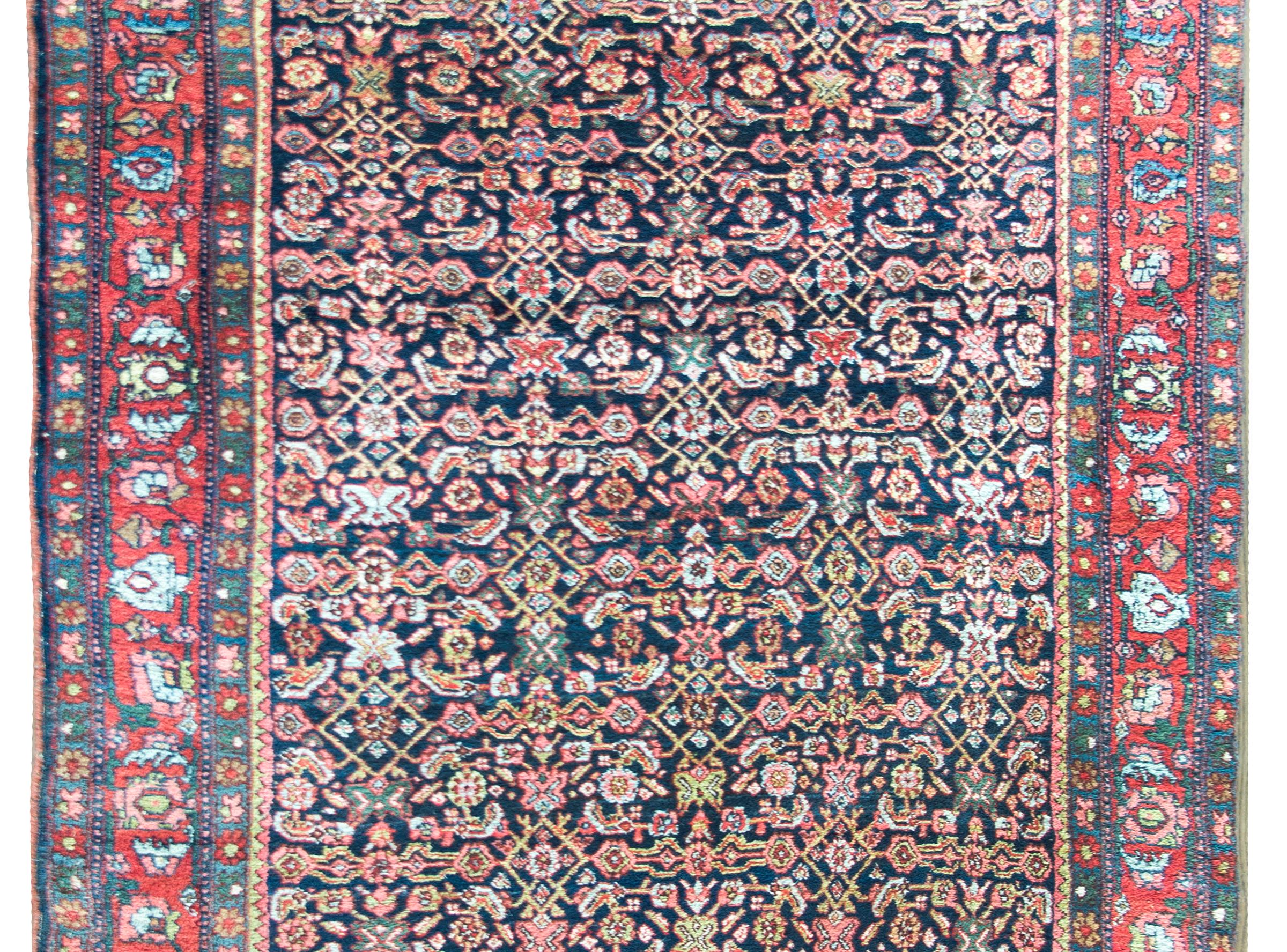 Remarquable tapis persan du début du 20e siècle à motif floral en treillis tissé d'une myriade de fleurs stylisées, de feuilles et de vignes enroulées, entouré d'une incroyable bordure complexe avec une large bande centrale à motif floral flanquée