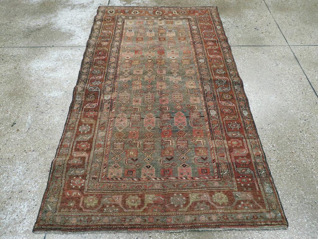 Un ancien tapis d'accent persan Bidjar. Les feuilles ivoires courbées à angle droit sont les éléments les plus saillants du motif Herati rustique et spacieux sur le sol d'ardoise subtilement abrasé de ce parterre de village kurde de l'ouest de la