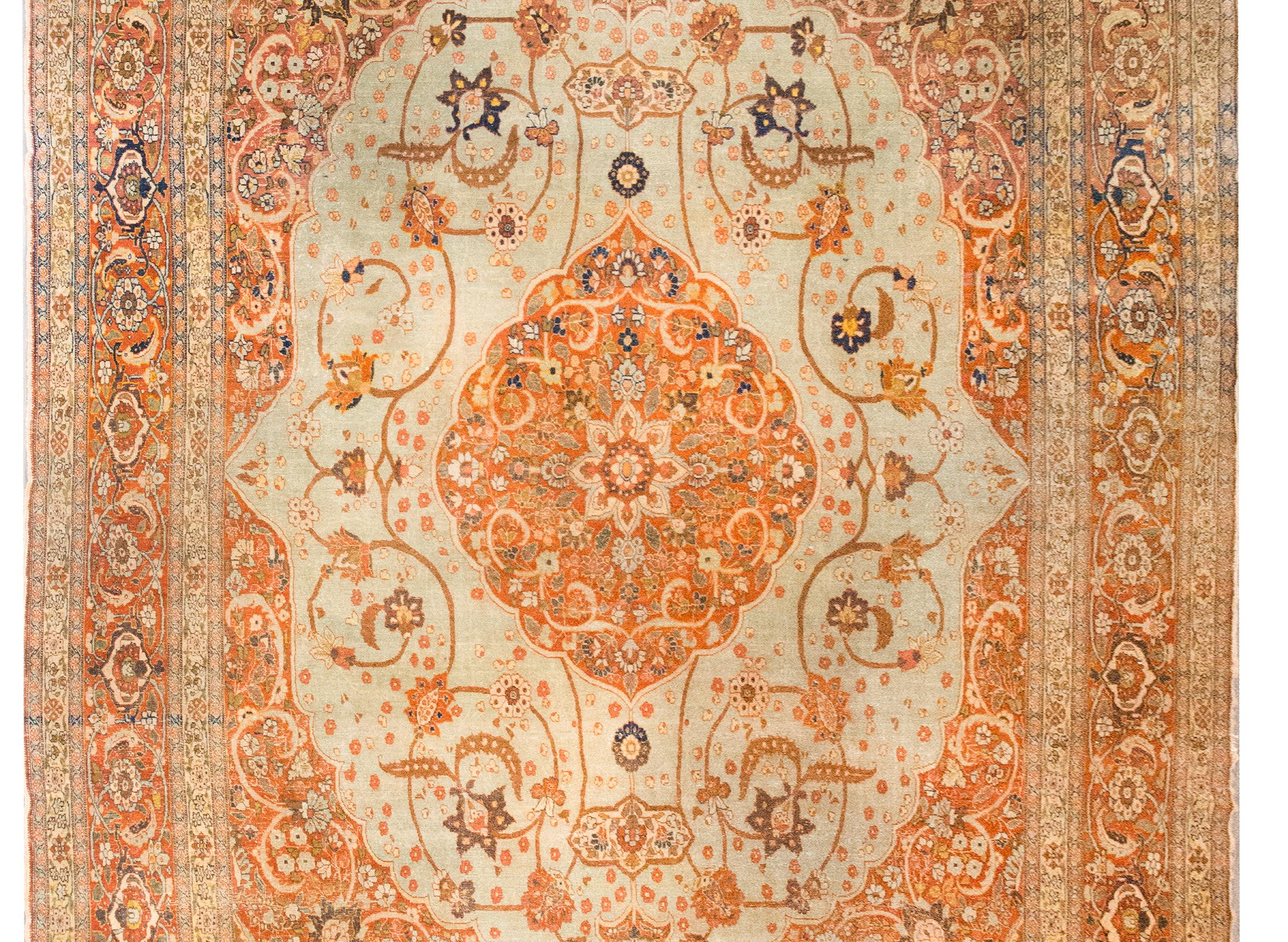 Questo tappeto persiano Hadji Jallili Tabriz dell'inizio del XX secolo, circa 1900, è un notevole esempio della raffinata arte per cui i tessitori di Tabriz sono famosi. Al centro, un grande medaglione floreale fa da sfondo a un campo di viti a