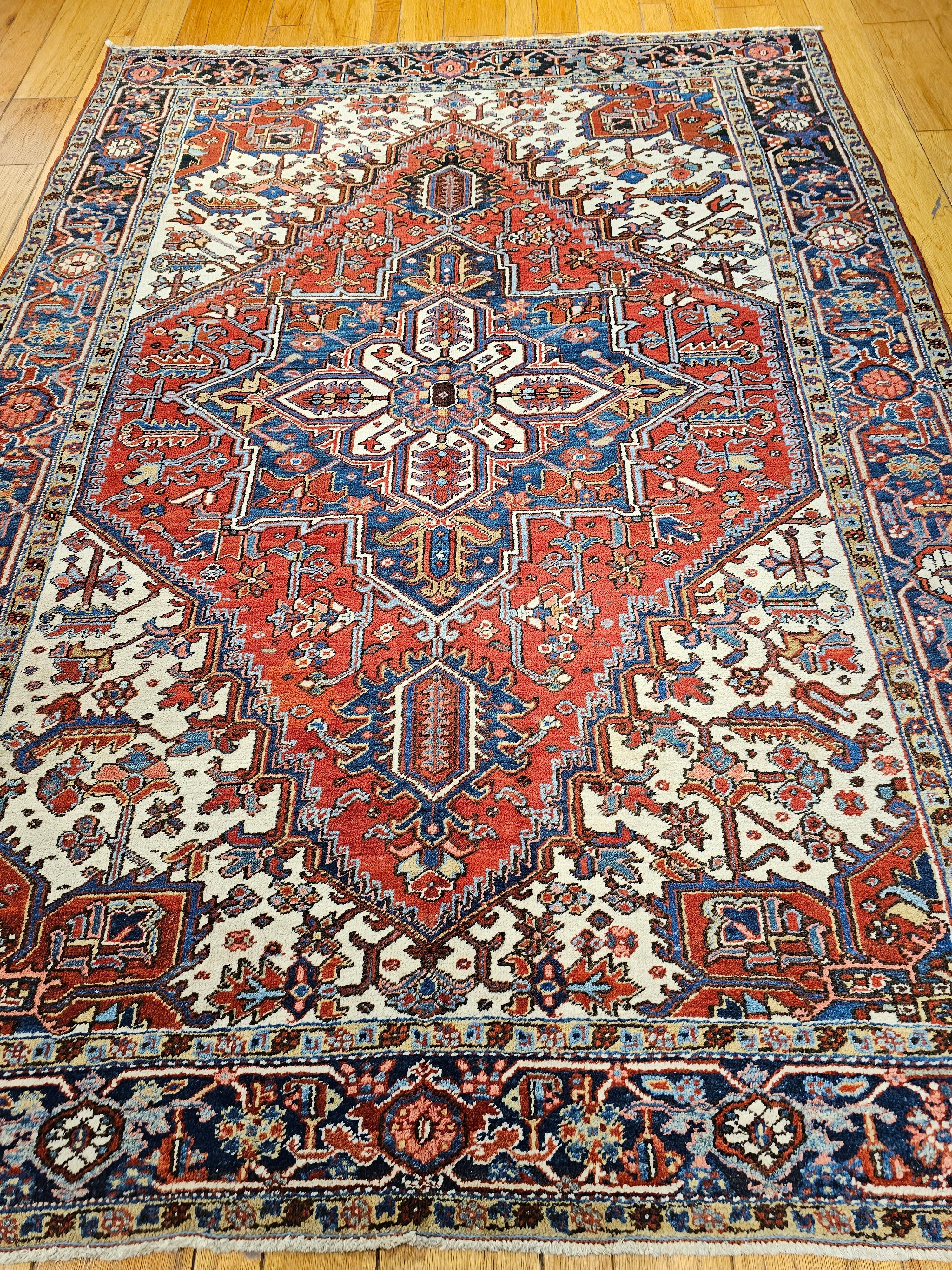 Dieser seltene und begehrte persische Heriz-Teppich aus dem ersten Viertel des 20. Jahrhunderts zeichnet sich durch eine leuchtende und ausgewogene Farbpalette aus, die tiefes Rot, Marineblau, französisches Blau, Elfenbein, zartes Rosa und Goldgelb