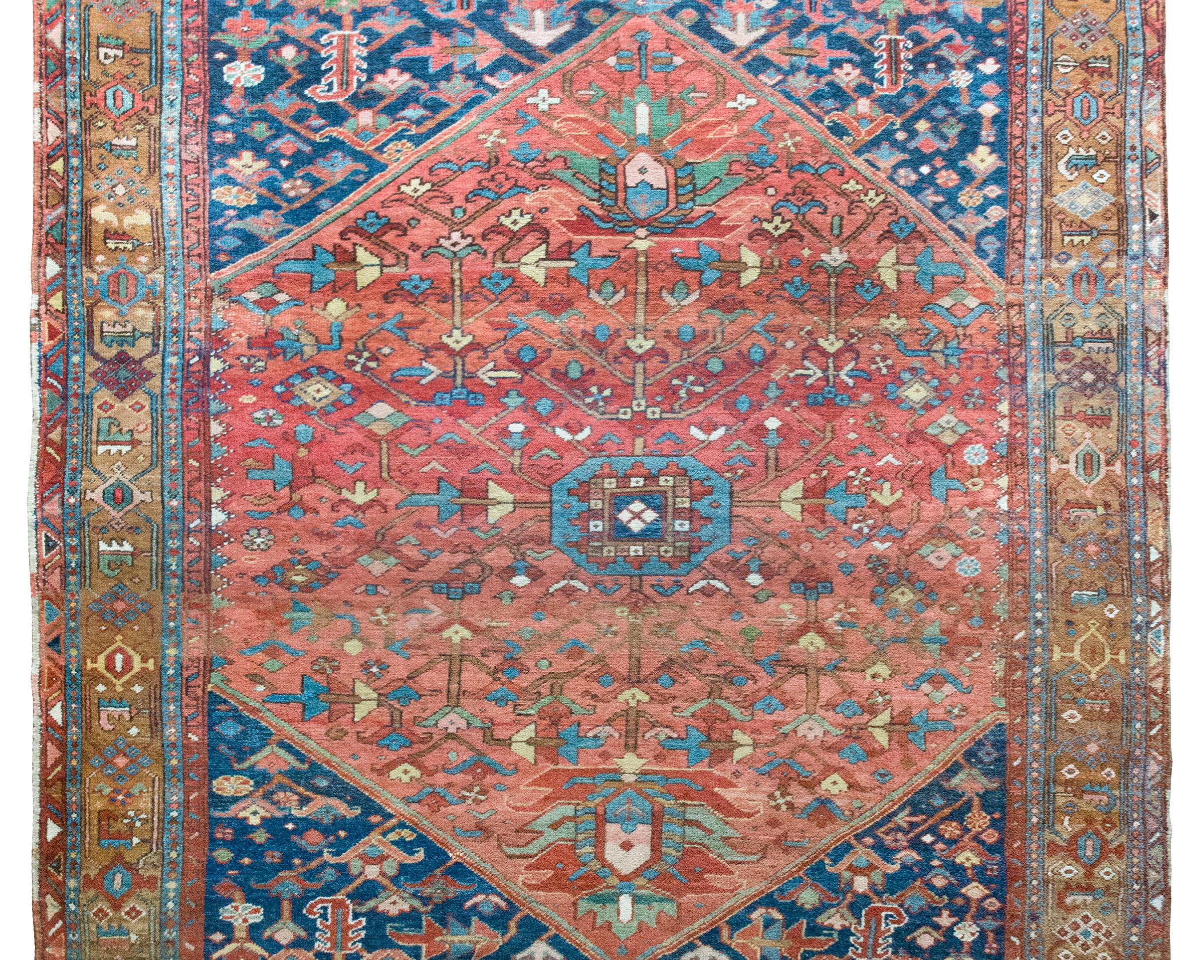 A wonderful early 20th century Persian Heriz rug with a primitive stylized floral pattern in the center listing amidst a field of even more dense woven flowers, and all surrounded by a wide border composed of multiple stripes of flowers and