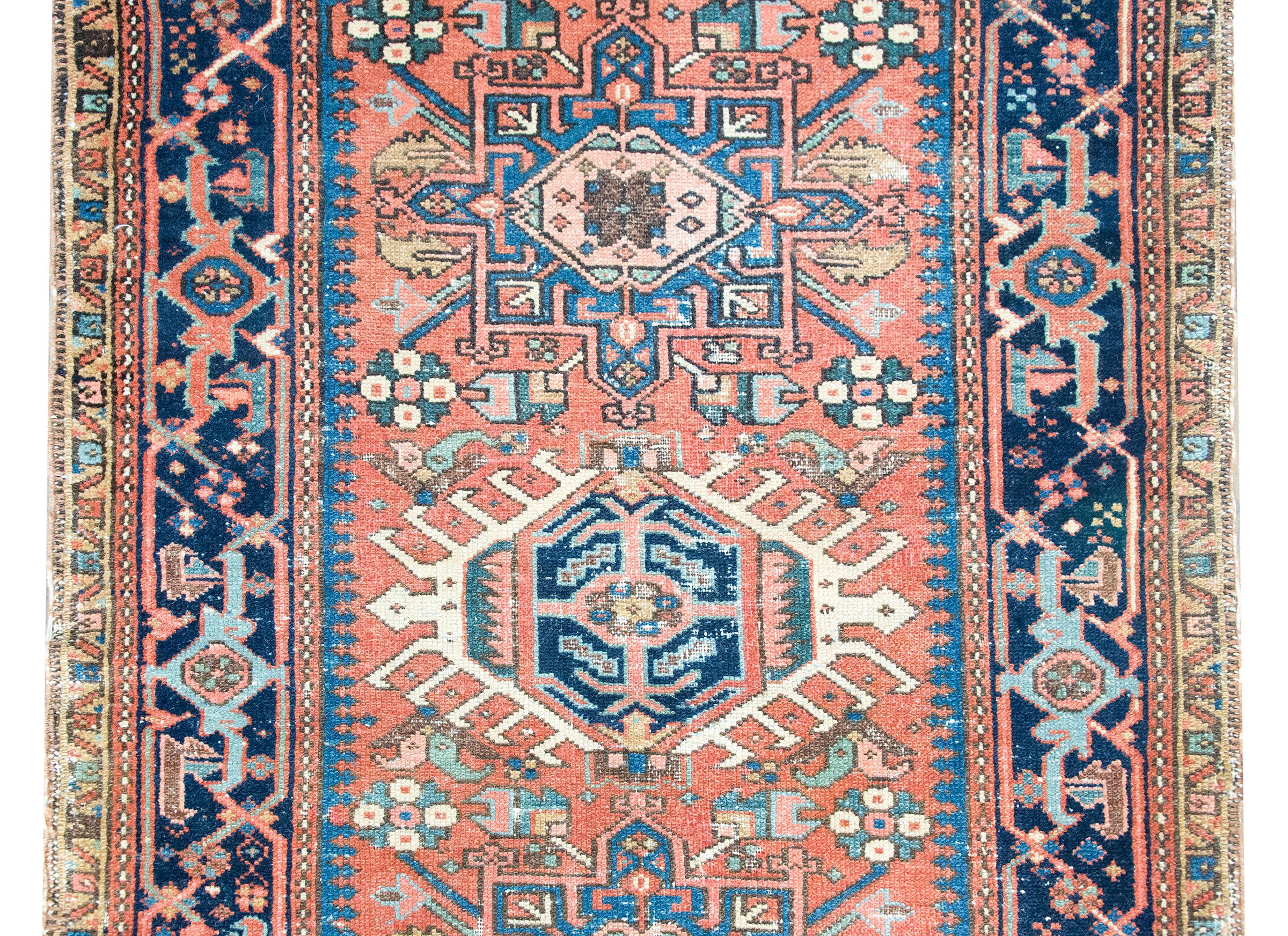 Ce tapis persan Heriz du début du XXe siècle est un exemple frappant du style géométrique audacieux qui fait la renommée de la région. Tissés dans les montagnes escarpées du nord-ouest de l'Iran, près de Tabriz, les tapis Heriz sont fabriqués par