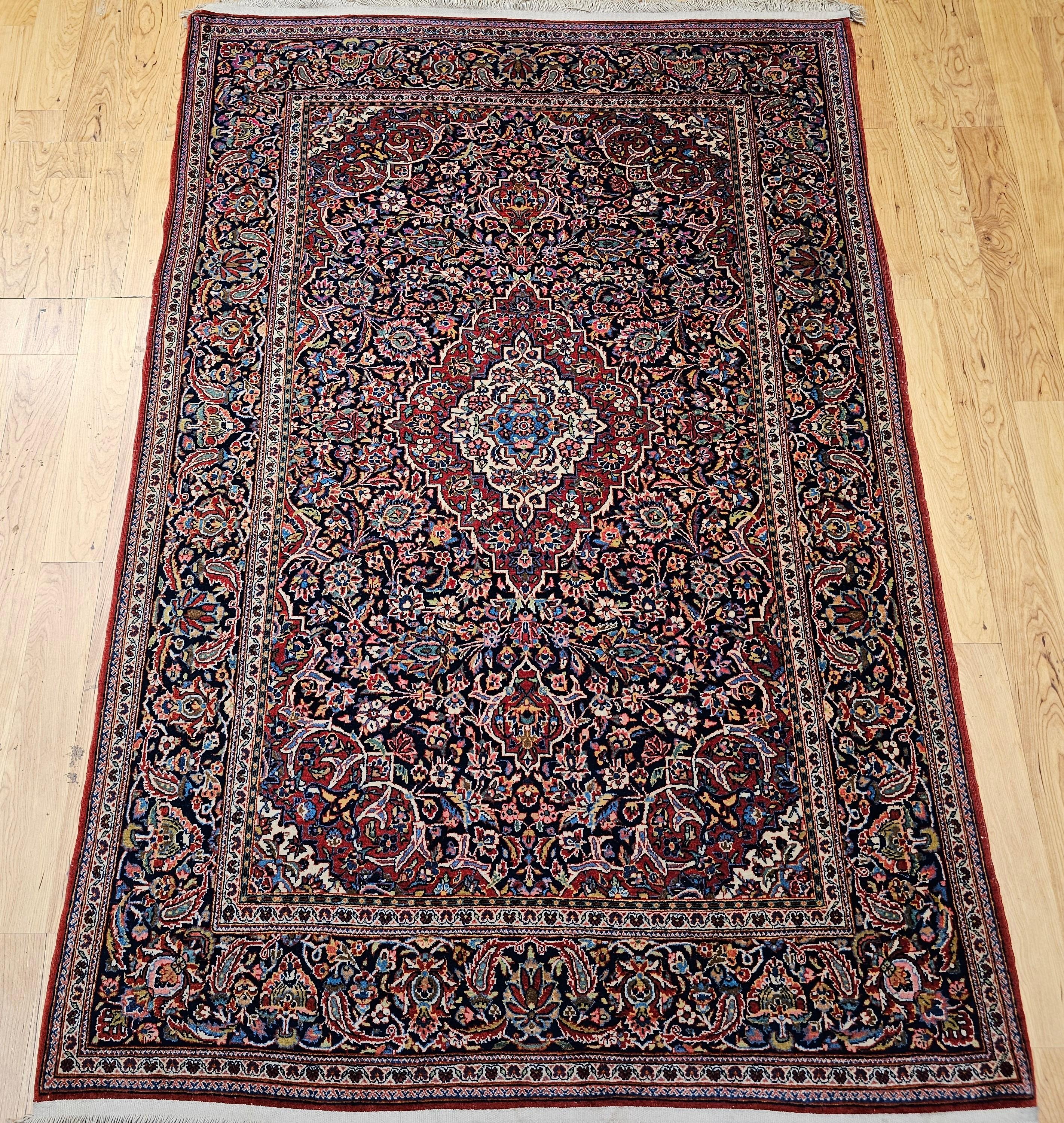 Magnifique tapis persan vintage de Kashan, méticuleusement noué à la main au début des années 1900. Cette pièce exquise incarne les principes de conception classiques et utilise la laine lumineuse et résistante pour laquelle les grands ateliers de