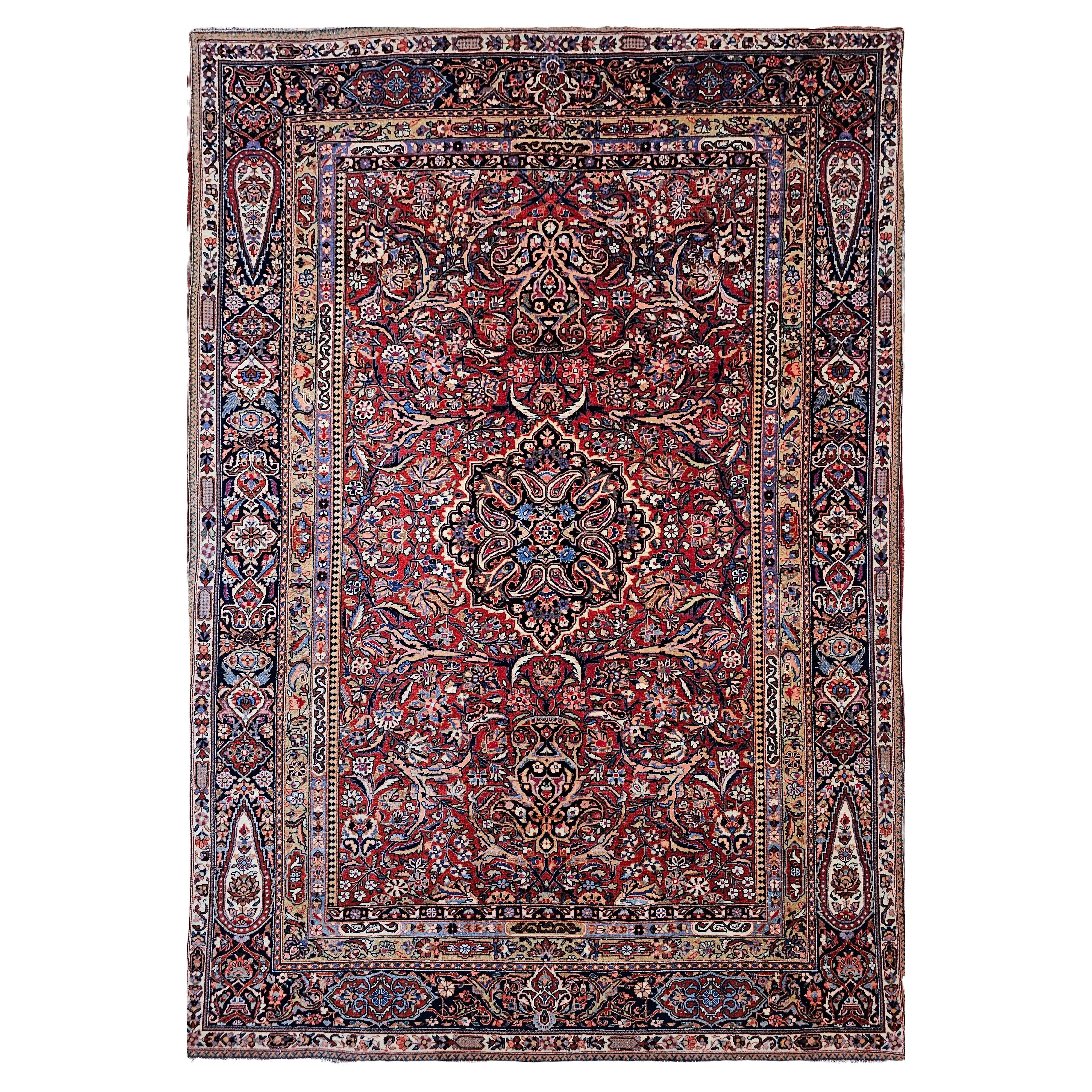 Tappeto persiano Kashan dei primi del Novecento con disegno floreale in rosso, marina e avorio