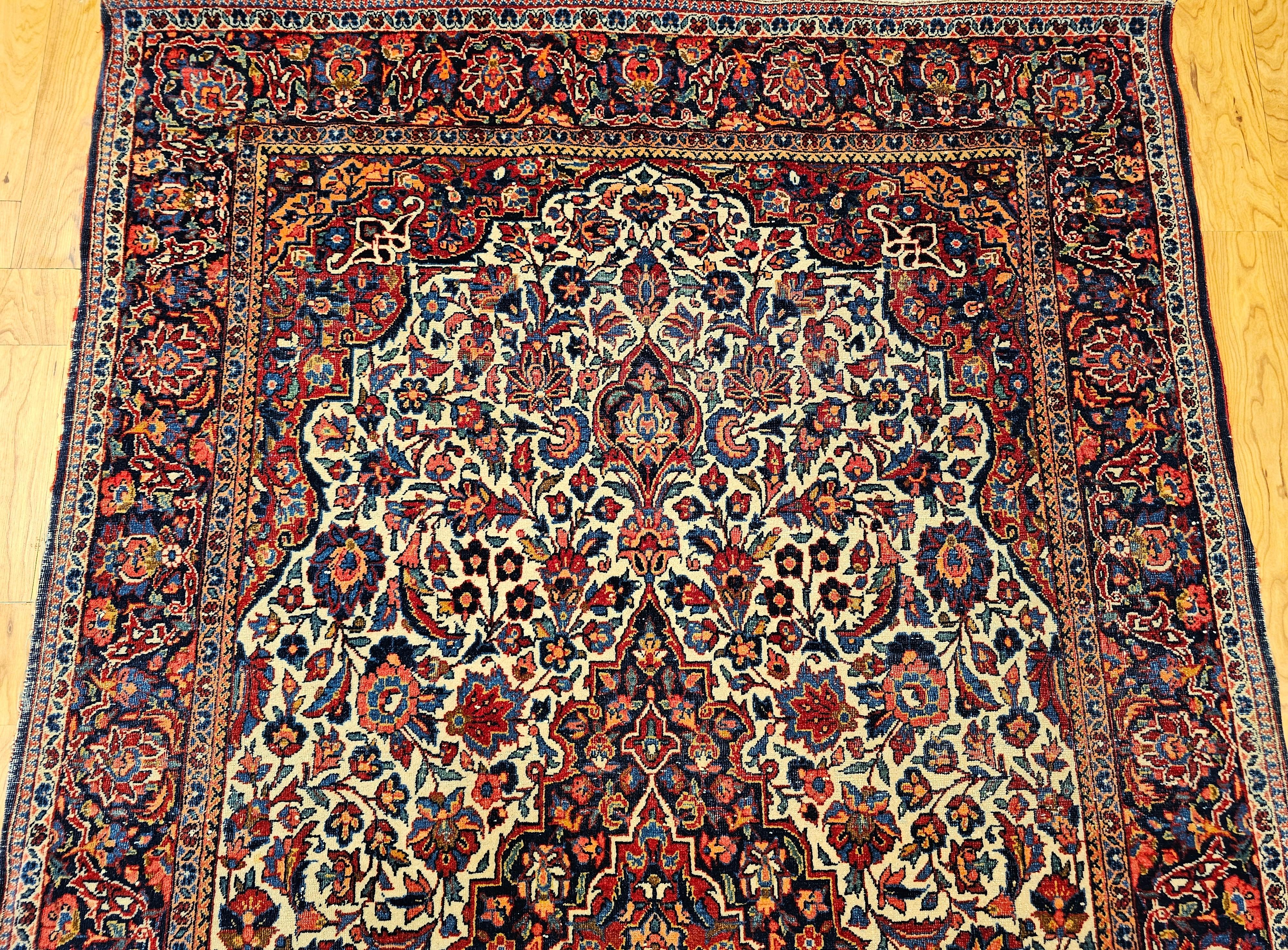 Perse Tapis persan Kashan du début du XXe siècle en ivoire, bleu marine, rouge, vert et rose en vente