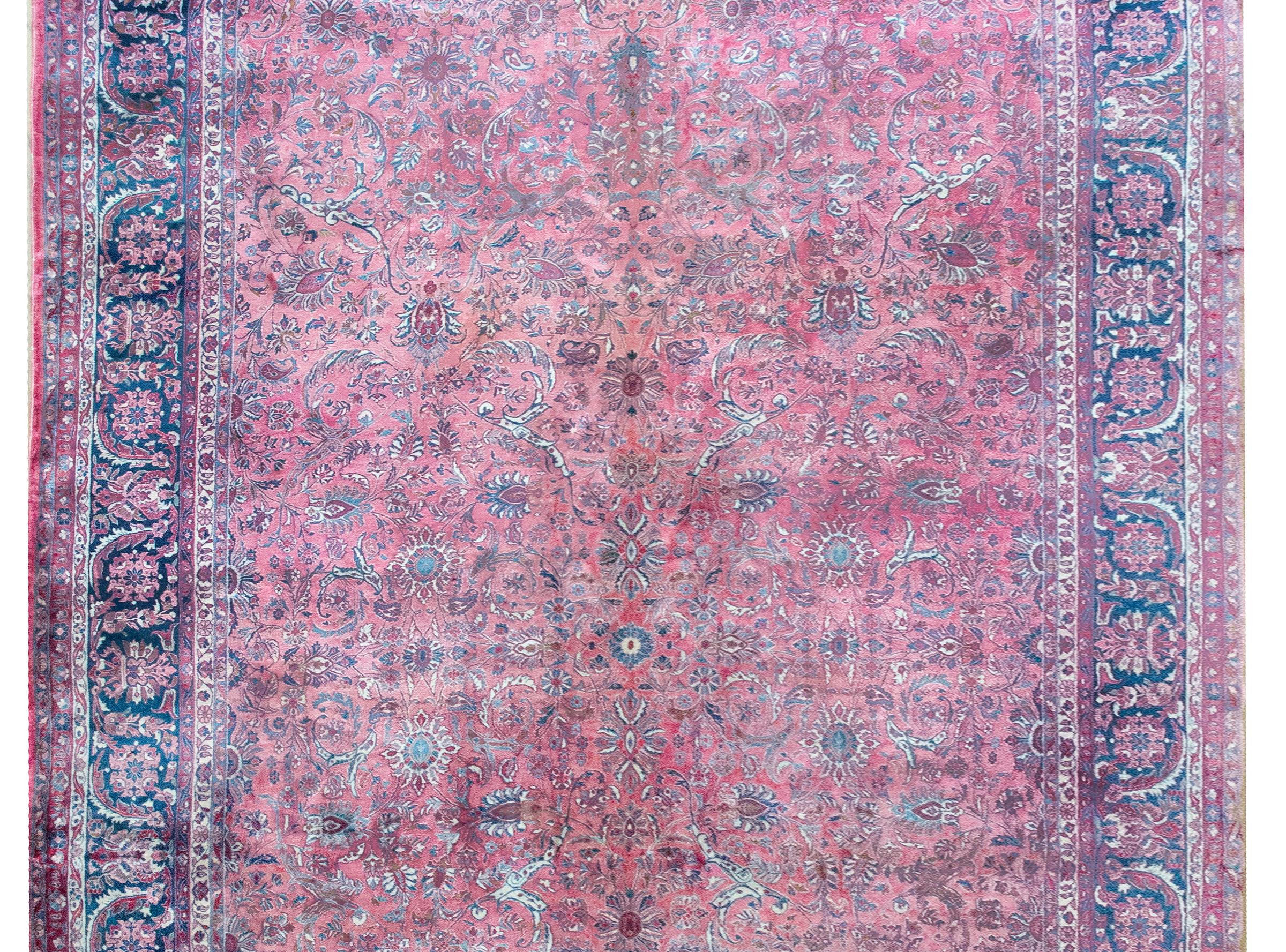 Questo tappeto persiano Kashan dell'inizio del XX secolo è un capolavoro di precisione e abbondanza floreale. Il suo design all-over è caratterizzato da un campo ipnotico di fiori densamente intrecciati e viti che scorrono, così intricato e