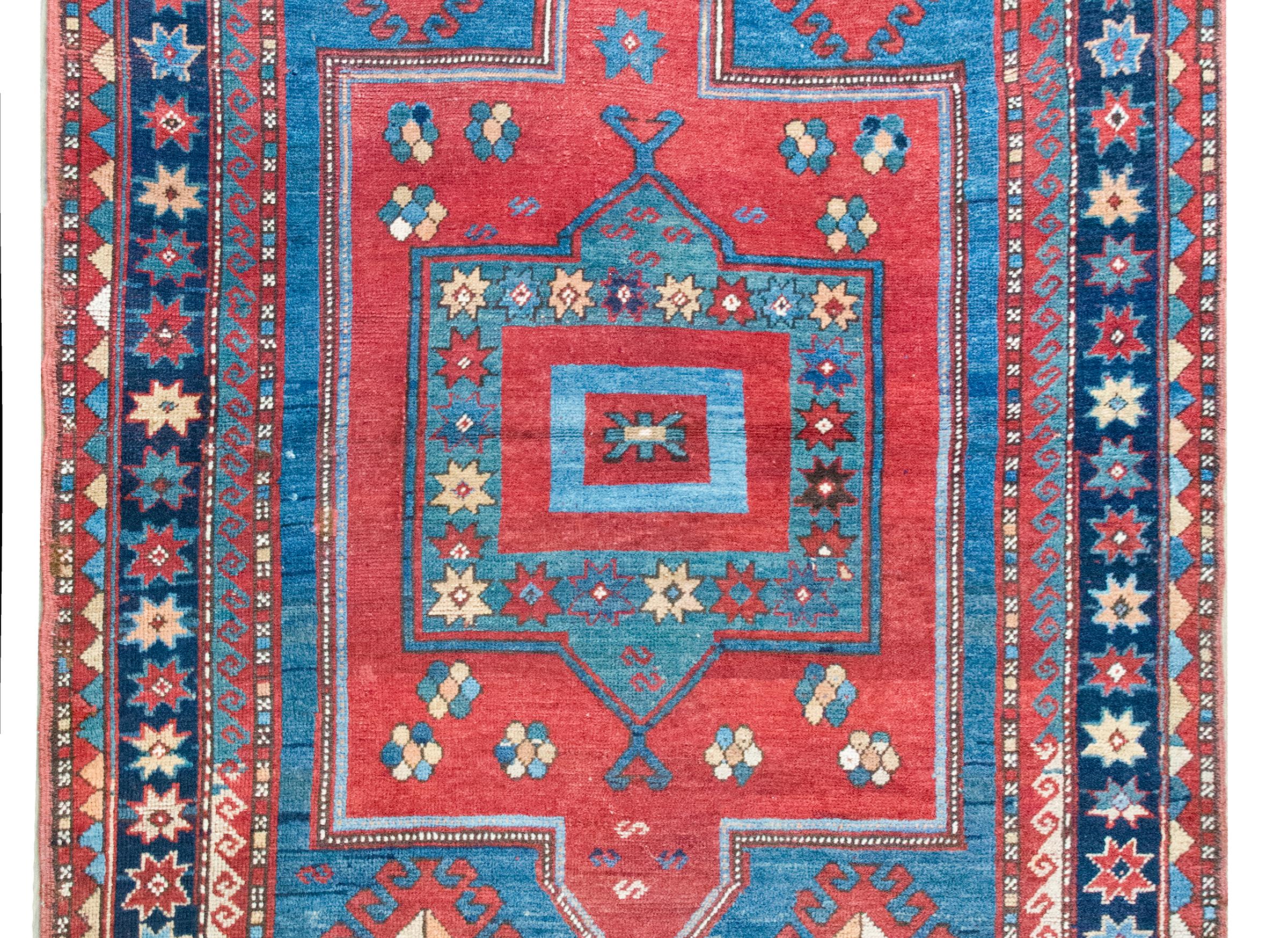 Un incredibile tappeto persiano Kazak dell'inizio del XX secolo con un grande medaglione floreale stilizzato centrale con diversi fiori stilizzati più piccoli inseriti, il tutto vivente in un campo di altri fiori e animali.  Il bordo è