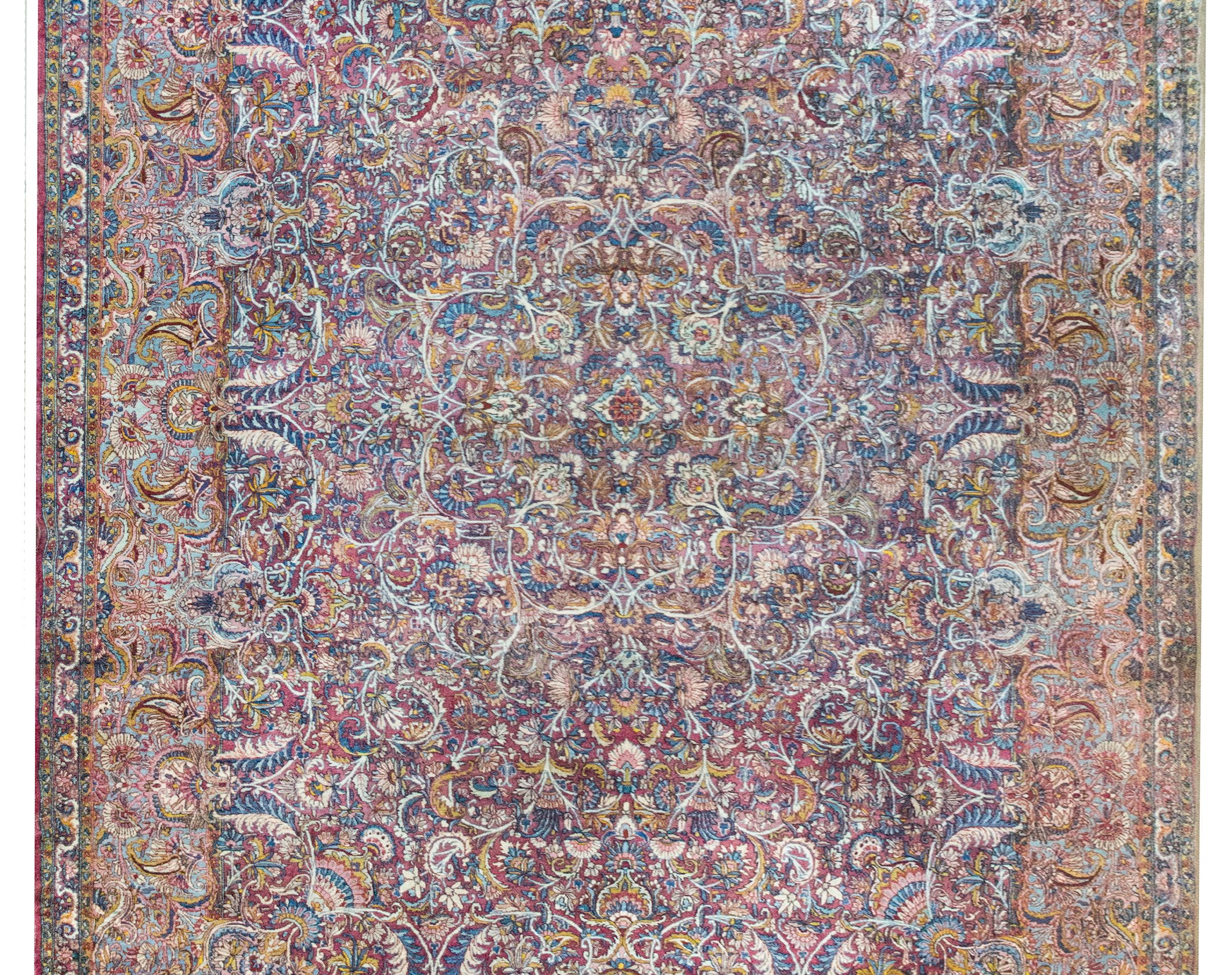 La más fascinante alfombra persa Kirman de principios del siglo XX, con un increíble campo densamente tejido de innumerables racimos florales que irradian desde un medallón central, y rodeado por el más elaborado borde con motivos florales, y todo