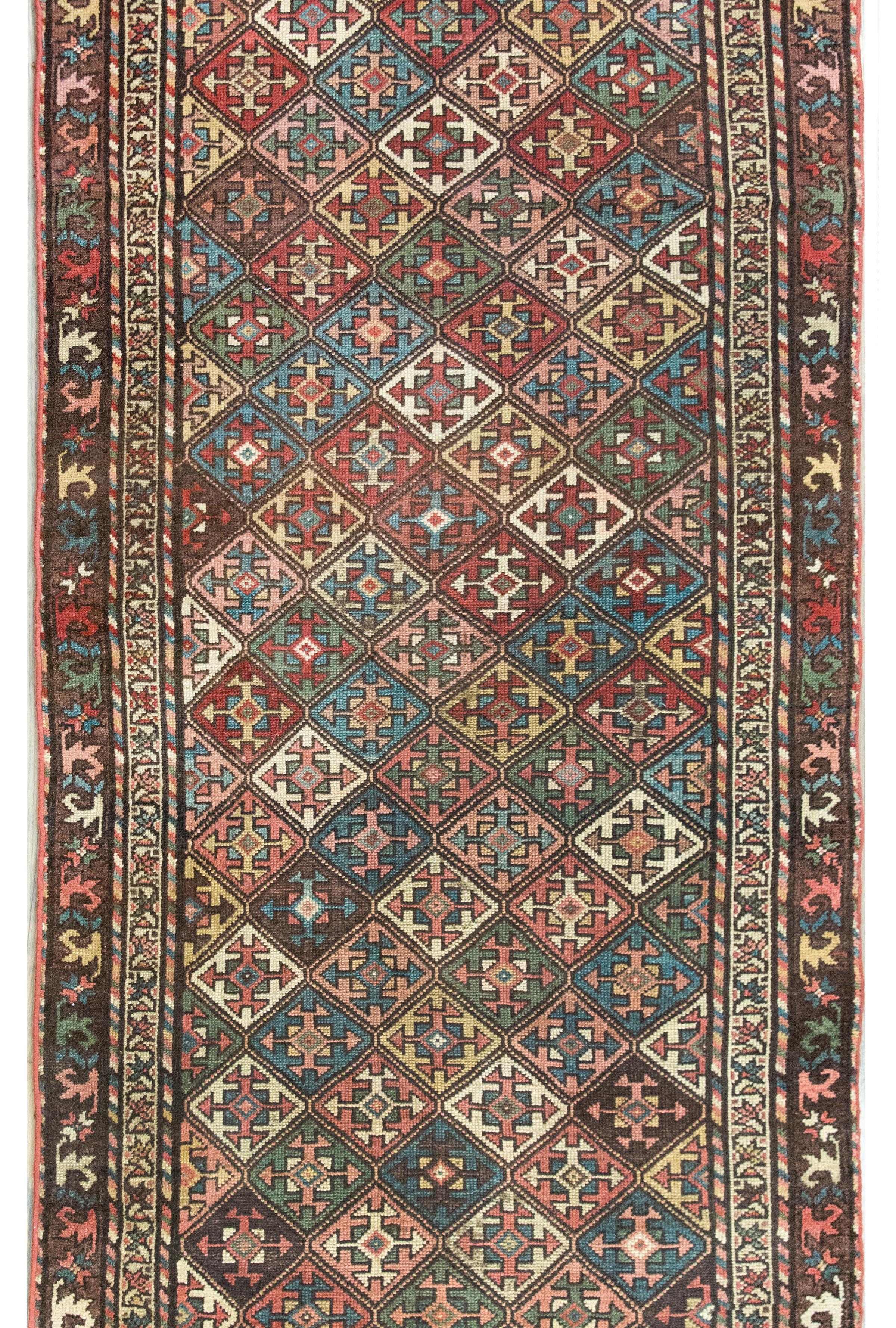 Un magnifico tappeto Kuba persiano dell'inizio del XX secolo con un meraviglioso motivo floreale geometrico stilizzato all-over tessuto in varie tonalità di cremisi, verde, oro, indaco e bianco e circondato da un semplice bordo con due distinti