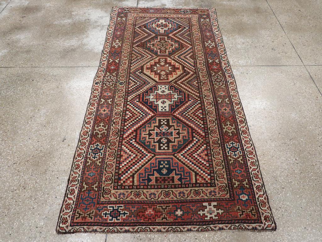 Un ancien tapis d'accent persan Kurdhish. Cinq guls cruciformes et demi de Memling sont formés dans un médaillon polaire défini par une mosaïque polychrome en zigzag de petits carrés de chaque côté. Les motifs en forme d'insecte dans la bordure sont