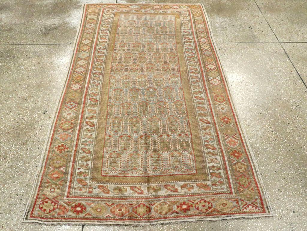 Una antigua alfombra persa kurda de acento. Hileras de botehs flotantes se extienden hasta el campo marrón de esta alfombra de pueblo persa occidental. El borde exterior principal presenta ashiks (rombos de dientes de sierra), mientras que el