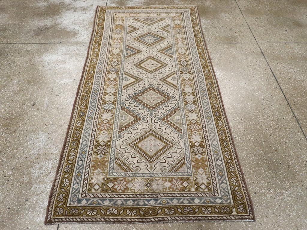 An antique Persian Kurdish rug. Four and one half “finger” edged lozenges and en suite side fillers define the pattern of this west Persian village scatter. Star rosettes almost totally cover the inner, main border and there is a reversing fan