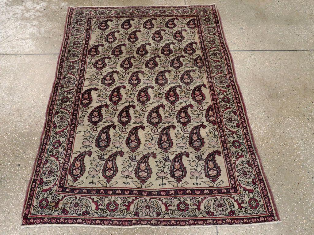 Un ancien tapis persan Lavar Kamran. Le champ ivoire présente neuf rangées de botehs tournés vers la droite, séparés par de petites gerbes de feuilles. La bordure bleu poudre présente de grandes feuilles de 