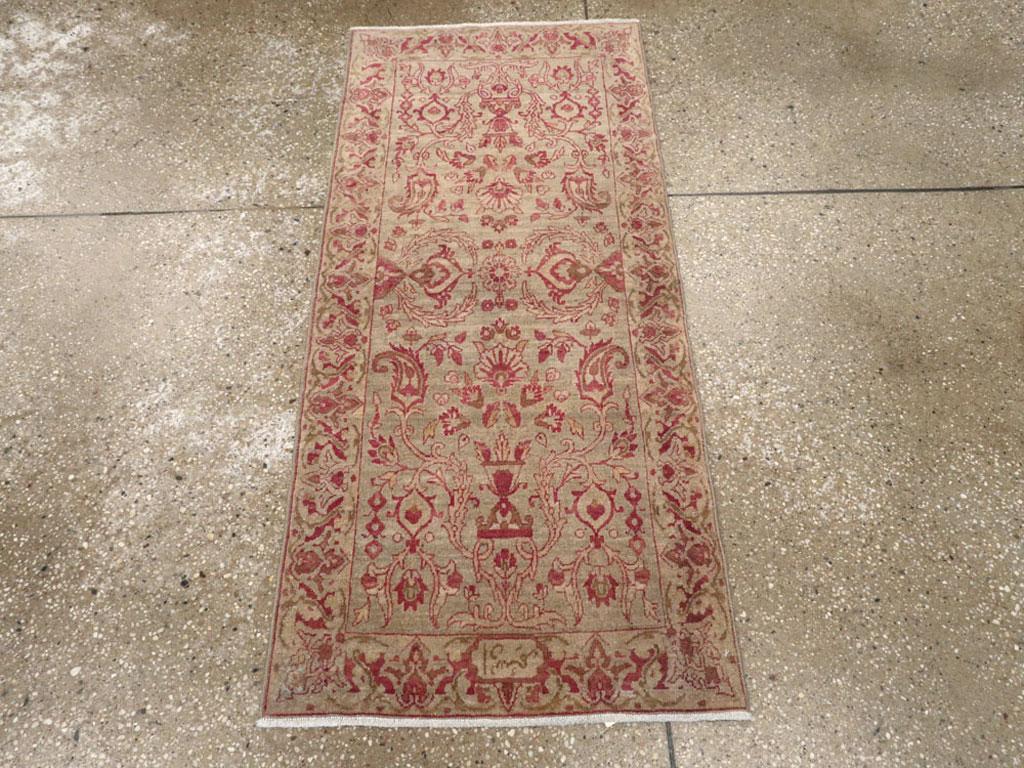 An antique Persian Lavar Kerman rug. This beige-tan field Kerman displays a boteh, vase and winged palmette pattern within a buff border of flowers and Impressionistic leaves. A cartouche at the top provides the name of the commissioning