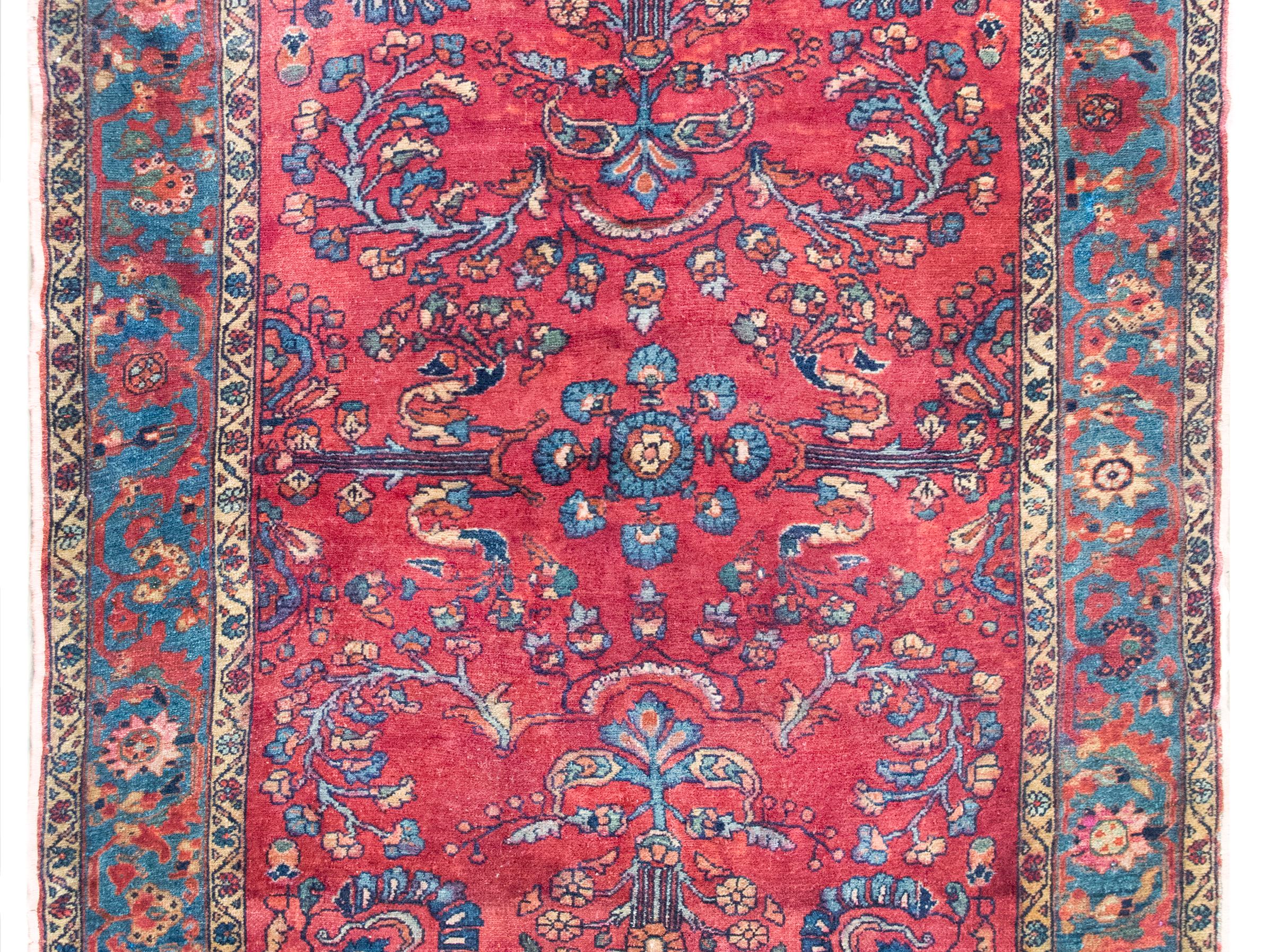 A beautiful early 20th century Persian Lilihan rug with a mirrored floral pattern with myriad floral clusters, surrounded by a border with more flowers and scrolling vines, and all woven in traditional Lilihan colors of pinks, cranberries, indigo,