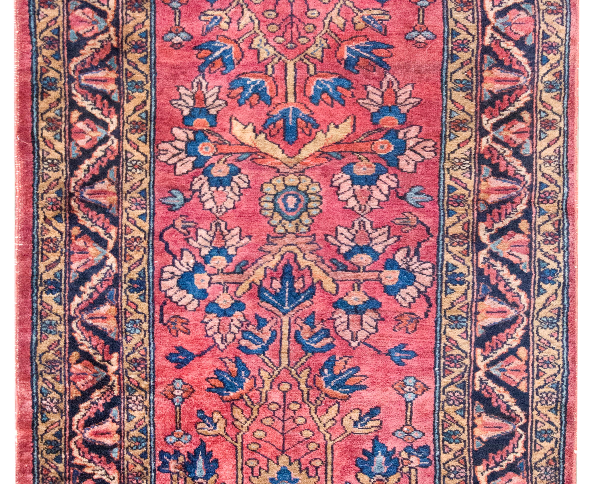 Un dolce tappeto persiano Lilihan dell'inizio del XX secolo con un semplice motivo floreale e di scorrimento a specchio, circondato da un ampio bordo con molteplici foglie e motivi floreali, il tutto tessuto in lana color mirtillo rosso, crema, rosa
