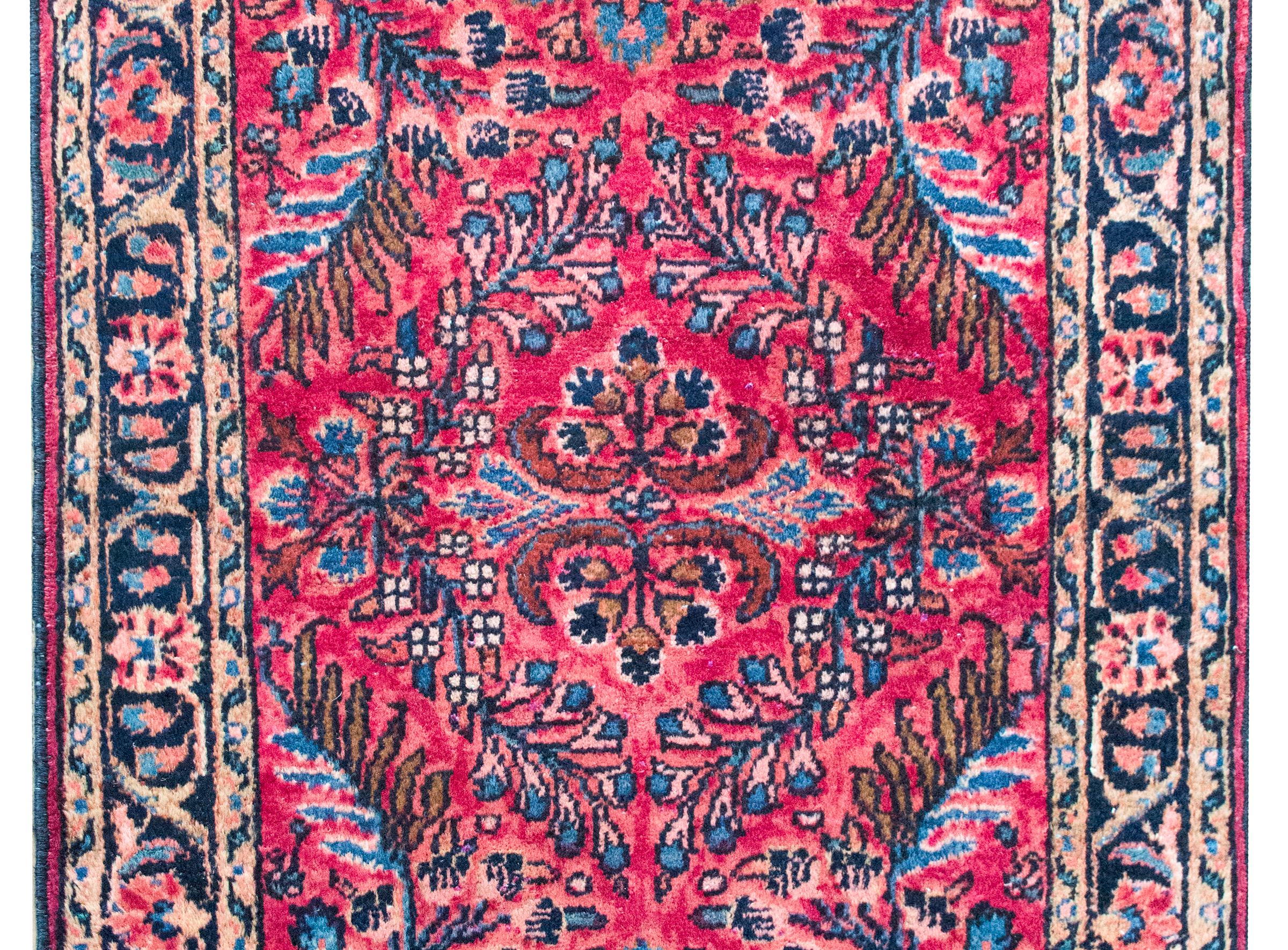 Dieser persische Lilihan-Teppich aus dem frühen 20. Jahrhundert zeichnet sich durch ein wunderschönes, gespiegeltes Blumenmuster aus, bei dem sich schwungvolle, belaubte Zweige und blühende Büschel in einem rhythmischen, symmetrischen Muster über