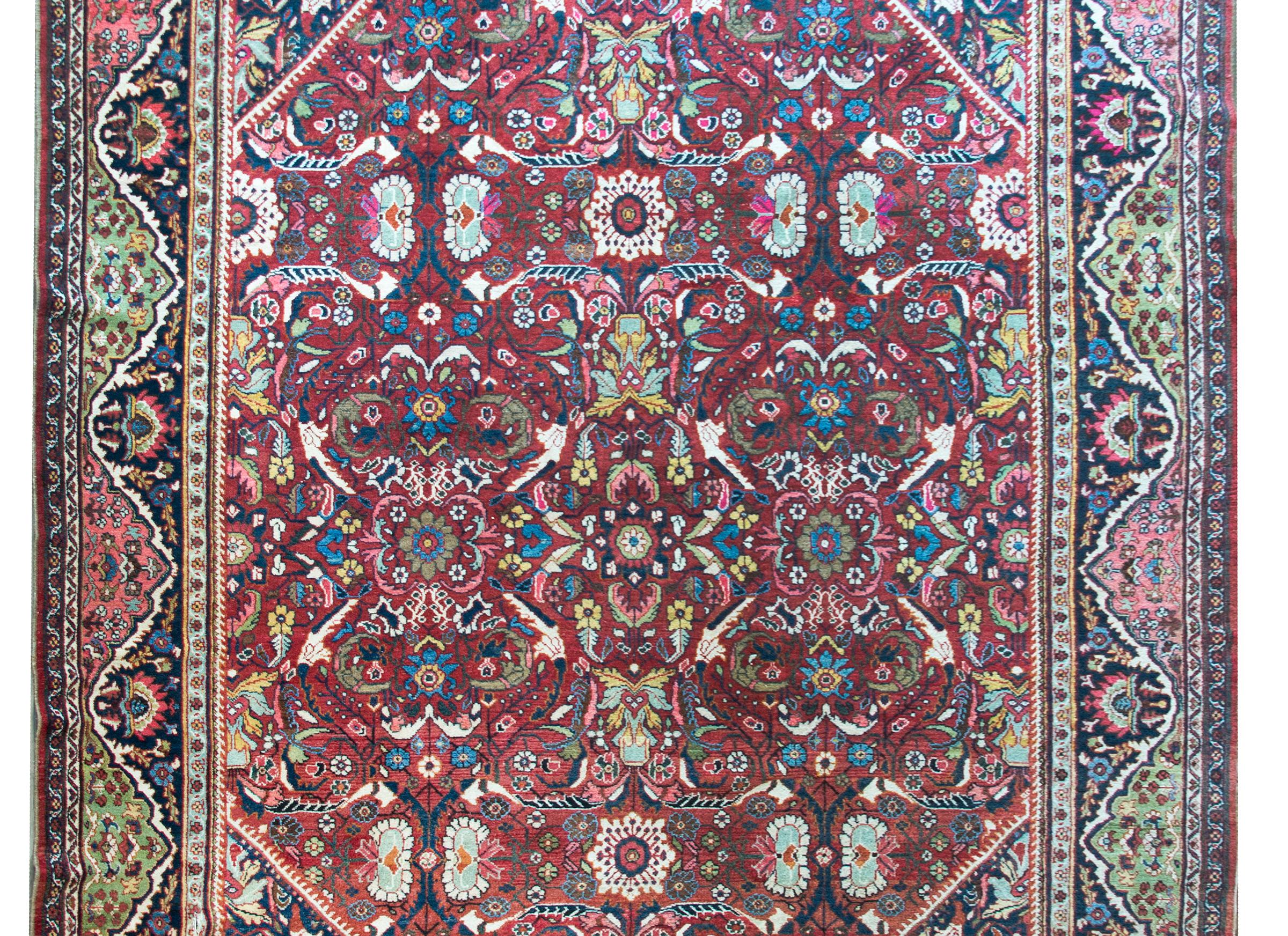 A spectacular early 20th century Persian Mahal rug with an all-over mirrored floral pattern with large and small flowers and leaves in a trellis pattern, and surrounded by border with repeated flowers, and all woven in myriad colors including