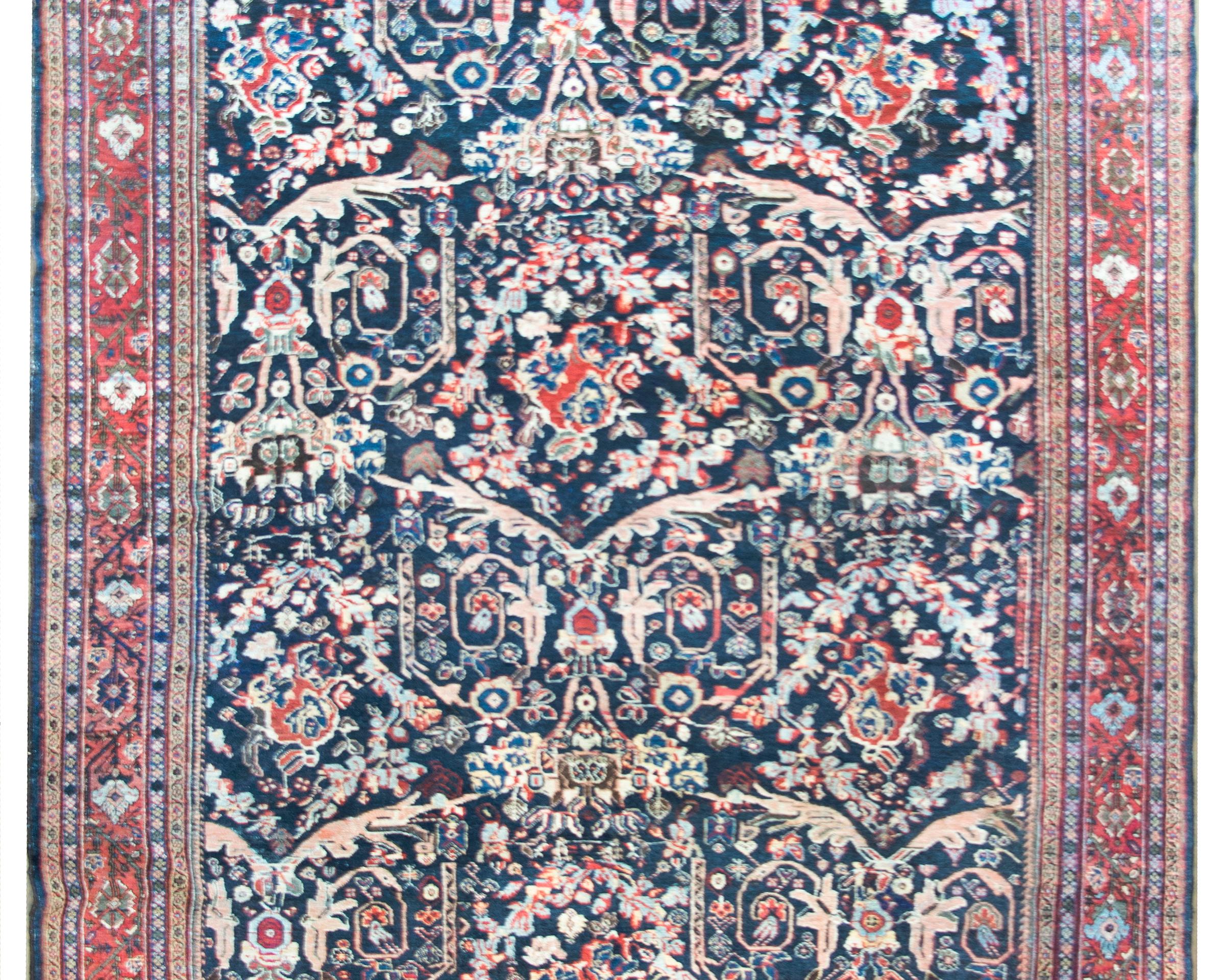 An incredible early 20th century Persian Mahal rug with the most wonderful all-over trellis floral pattern with myriad flowers, leaves, and scrolling vines woven in crimson, cream, light and dark indigo, pink, and cream, and surrounded by the most