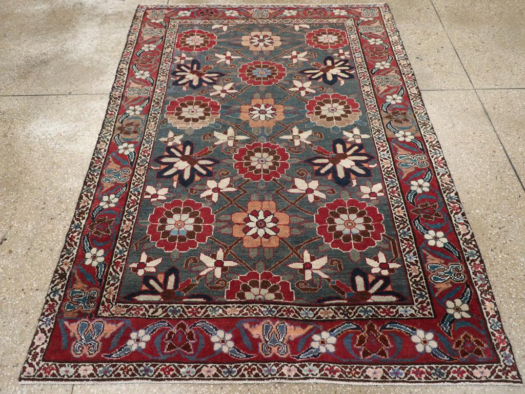 Un ancien tapis d'accent persan Malayer. Un motif de treillis floral coloré à grande échelle de Minas remplit le champ vert chasseur de ce tapis de village. Des palmettes en forme de chauve-souris et des rosettes ivoire sont reliées par un rinceau