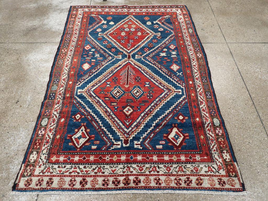 Ein antiker persischer Malayer Akzentteppich. Das dunkelblaue Feld trägt ein Medaillon mit einem doppelten Rautenstab. Die roten Rauten sind beide gestuft, aber von völlig unterschiedlicher Größe. Rosetten, kleine Rauten und eine stilisierte Pflanze