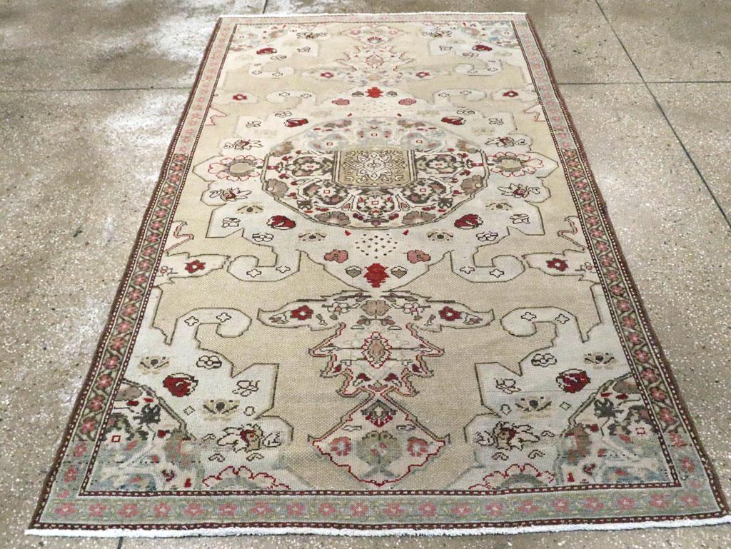 An antique Persian Malayer accent rug. The pale grey medallion and matching quarter corners are in a popular Azerbaijani pattern. The doubled pendants give it a boldness on the buff open ground. The ever-popular reversing palmette border is here